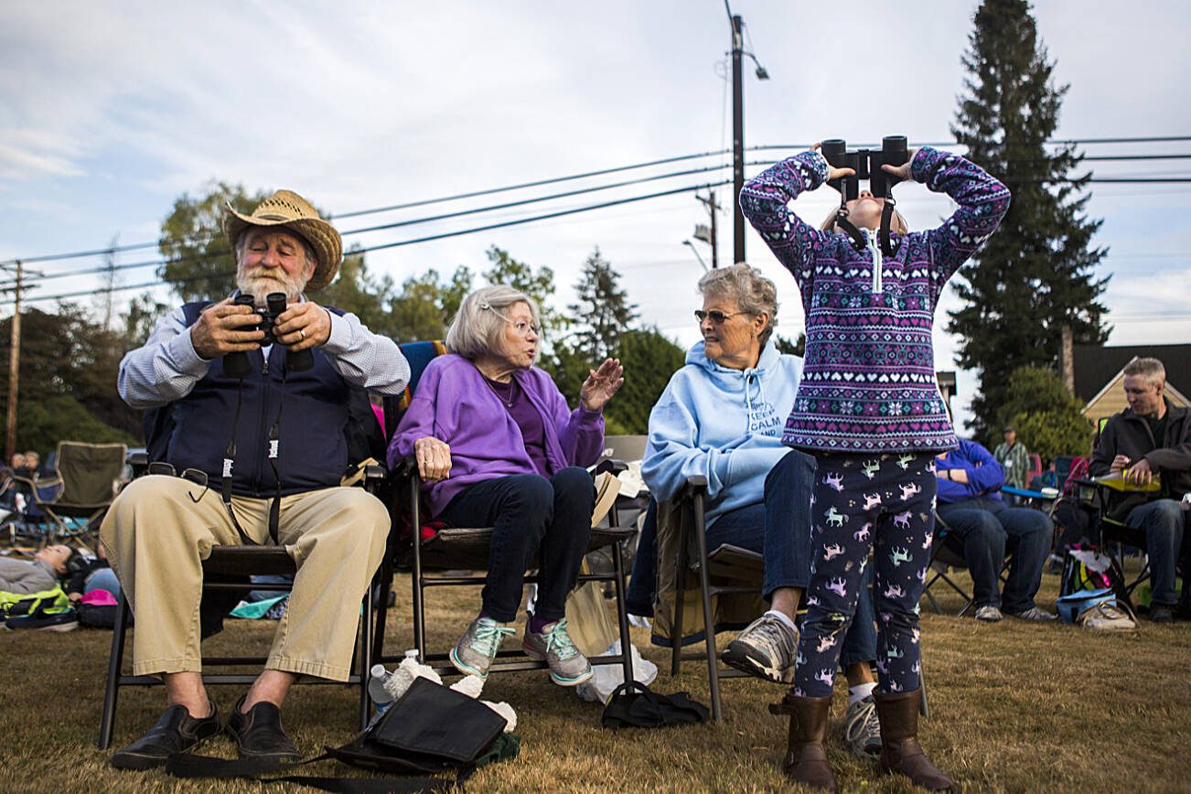 Anabelle Parsons, then 6, looks up to the sky with binoculars to watch the Vaux's swifts fly in during Swift's Night Out, Sept. 8, 2018 in Monroe. (Olivia Vanni / The Herald)