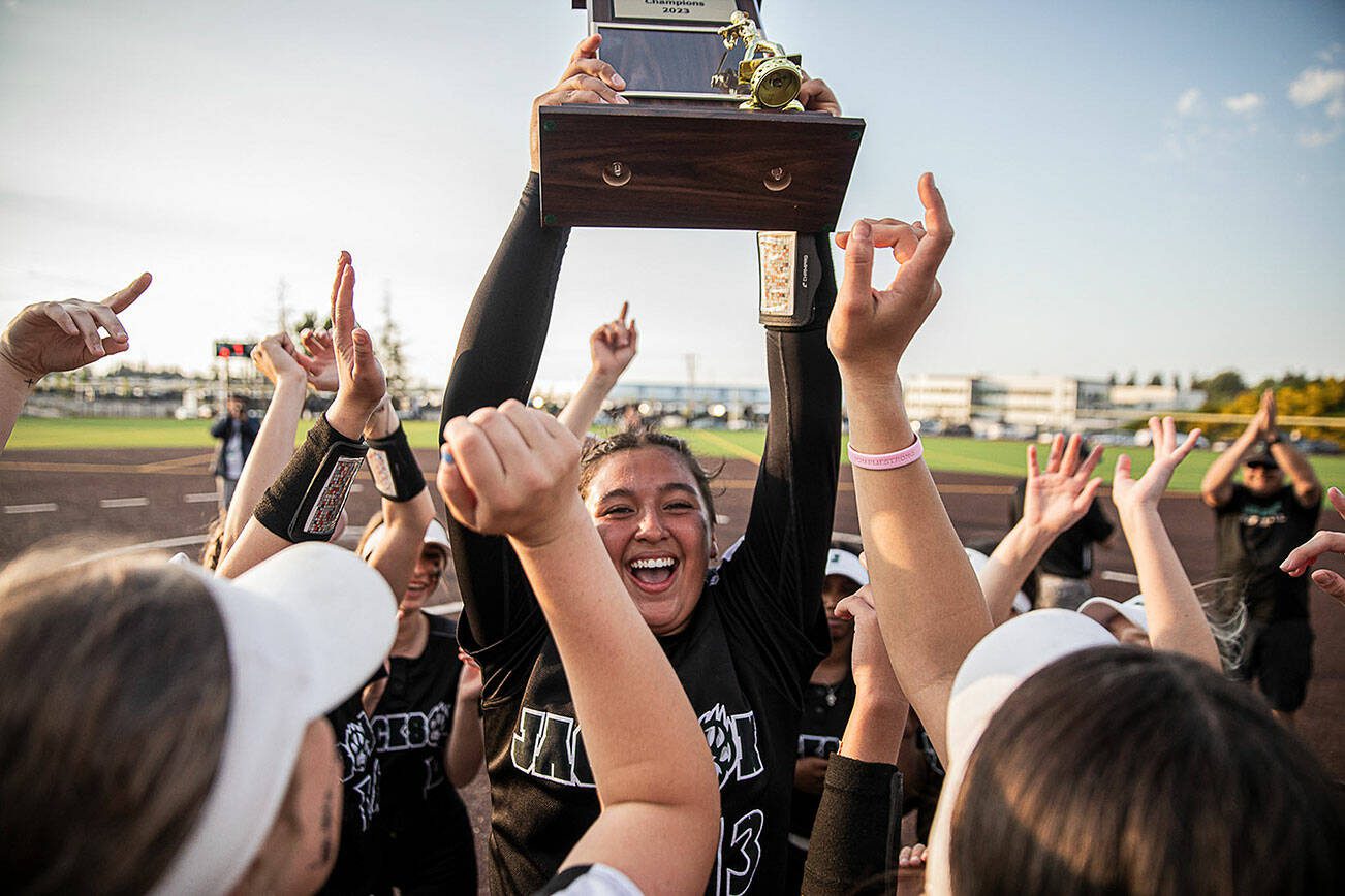 Jackson’s Yanina Sherwood lifts the district trophy in the air after beating Bothell to become the 3A district champions on Friday, May 19, 2023 in Everett, Washington. (Olivia Vanni / The Herald)