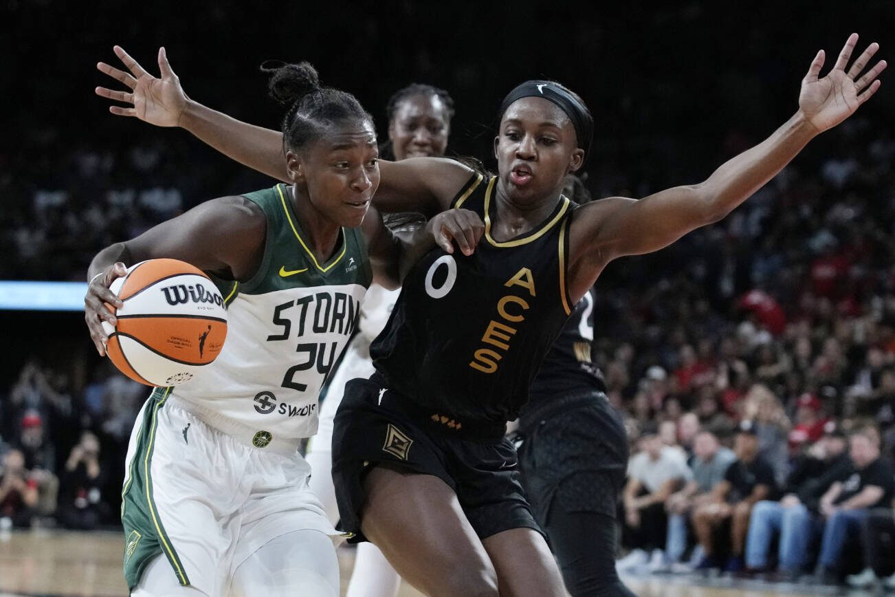 Seattle Storm guard Jewell Loyd (24) drives into Las Vegas Aces guard Jackie Young (0) during the second half in Game 2 of a WNBA basketball semifinal playoff series Wednesday, Aug. 31, 2022, in Las Vegas. (AP Photo/John Locher)