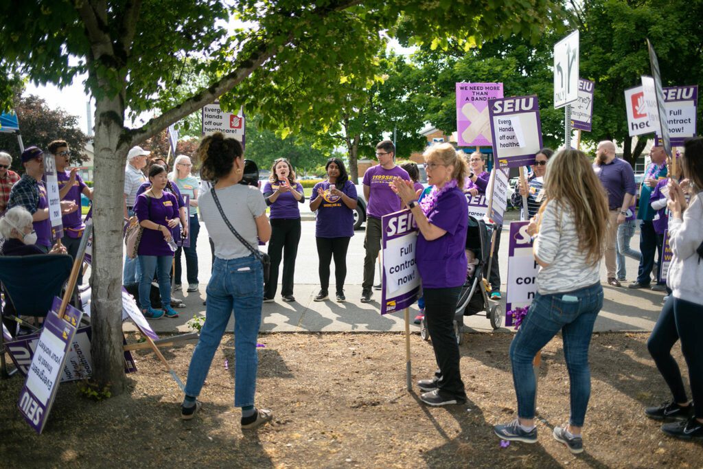 A crowd of SEIU Healthcare 1199NW members and supporters gather to listen to speakers address the group during a union protest in front of EvergreenHealth Monroe on Wednesday, May 24, 2023, in Monroe, Washington. (Ryan Berry / The Herald)
