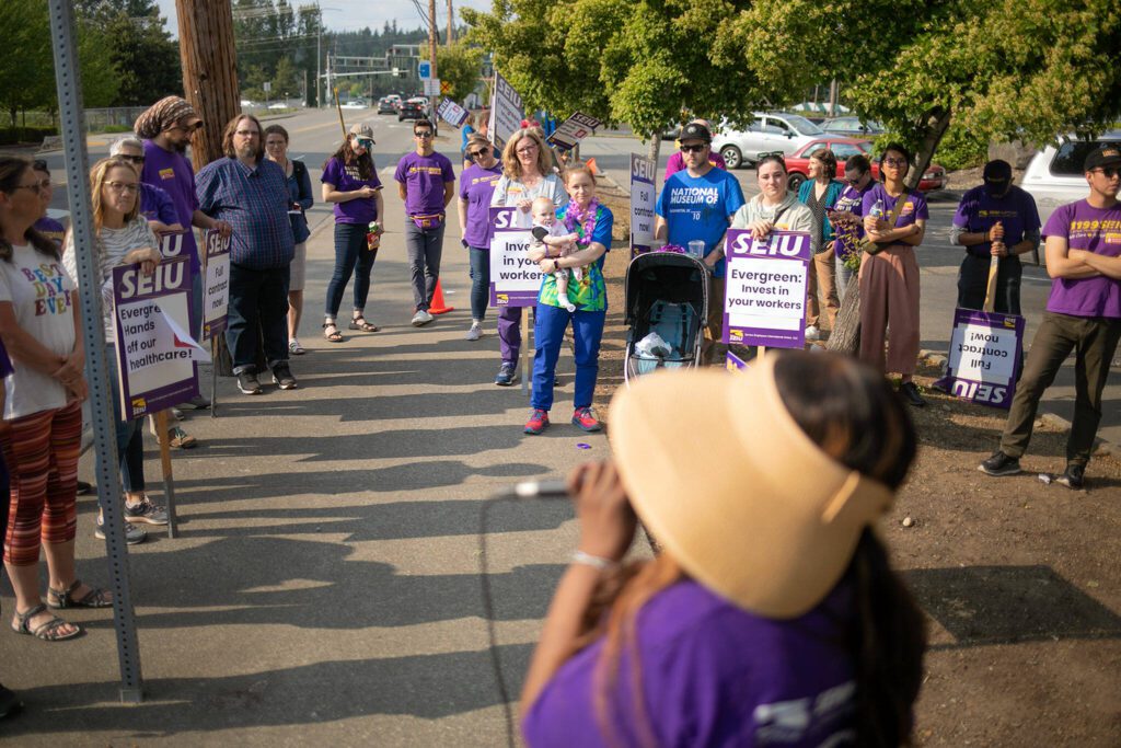 A group of SEIU Healthcare 1199NW members listen as Union President Jane Hopkins speaks during a picket in front of EvergreenHealth Monroe on Wednesday, May 24, 2023, in Monroe, Washington. (Ryan Berry / The Herald)
