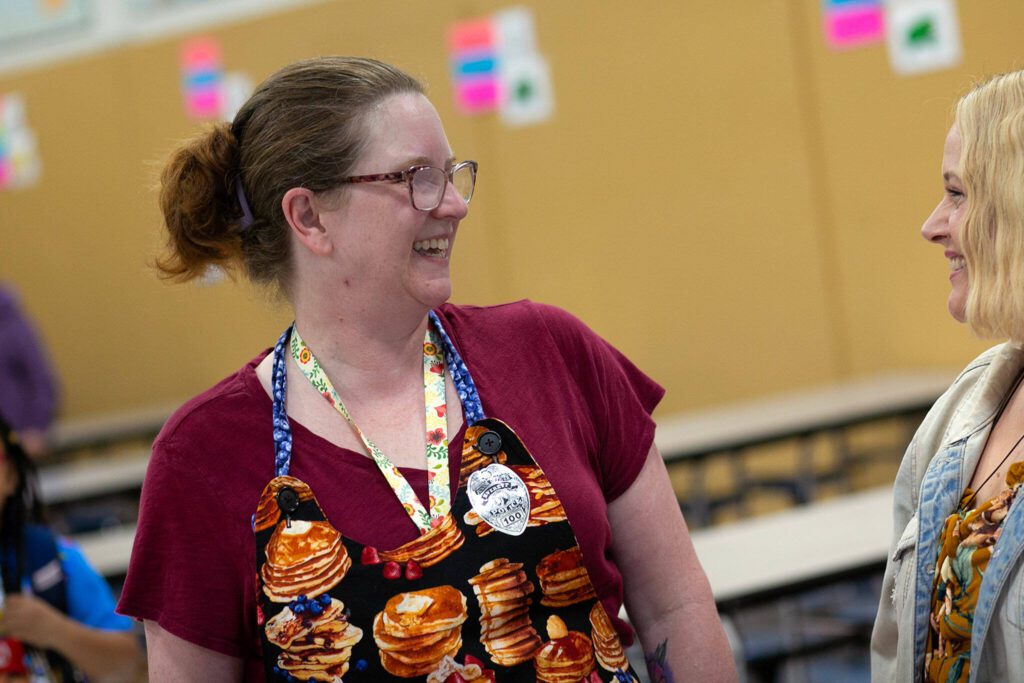 Teacher Stacey Wartenbee circles the cafeteria and chats with folks during a free pancake breakfast she organized at Lowell Elementary School on Friday, May 26, 2023, in Everett, Washington. (Ryan Berry / The Herald)
