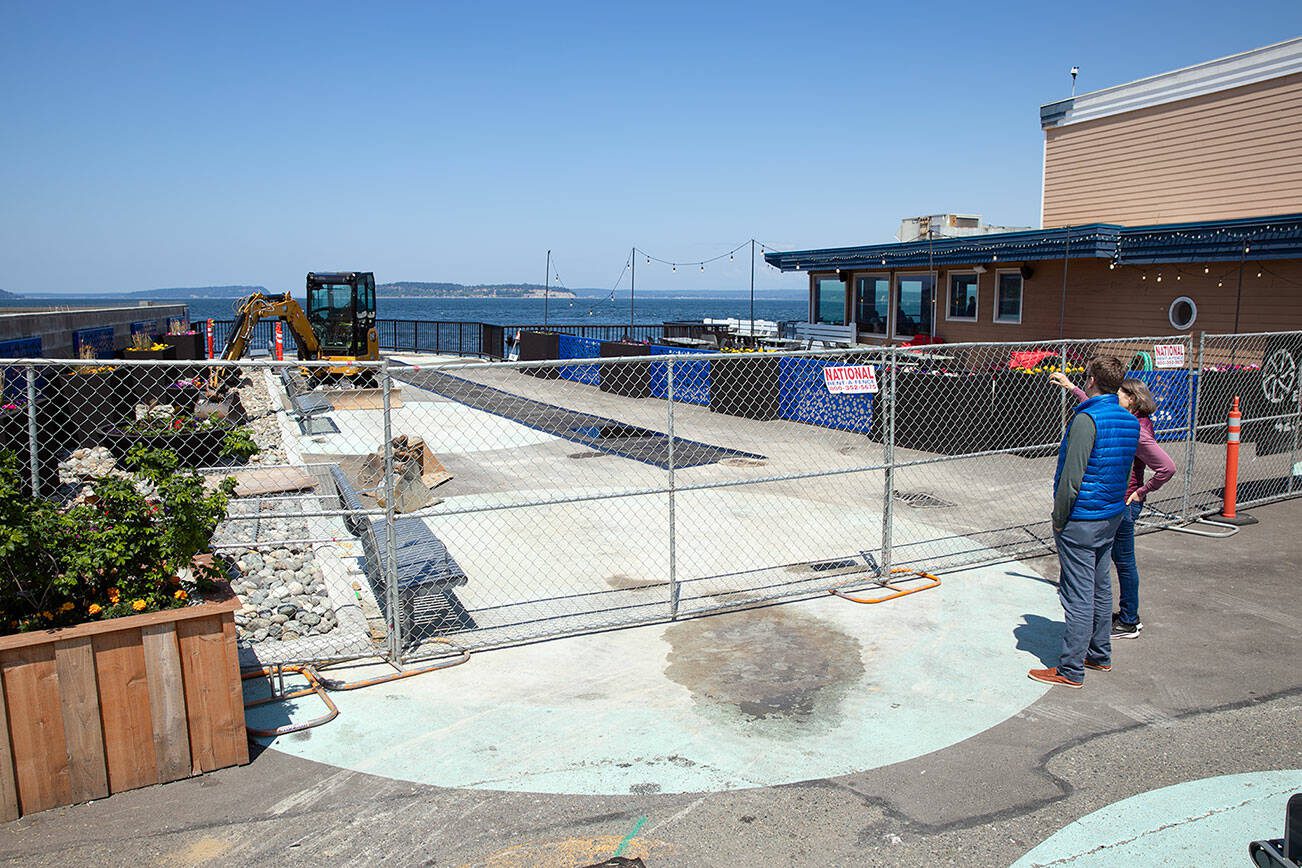 Passersby stop to look at the fenced-off parklet next to Ivar’s on Thursday, May 25, 2023, in Mukilteo, Washington. (Ryan Berry / The Herald)