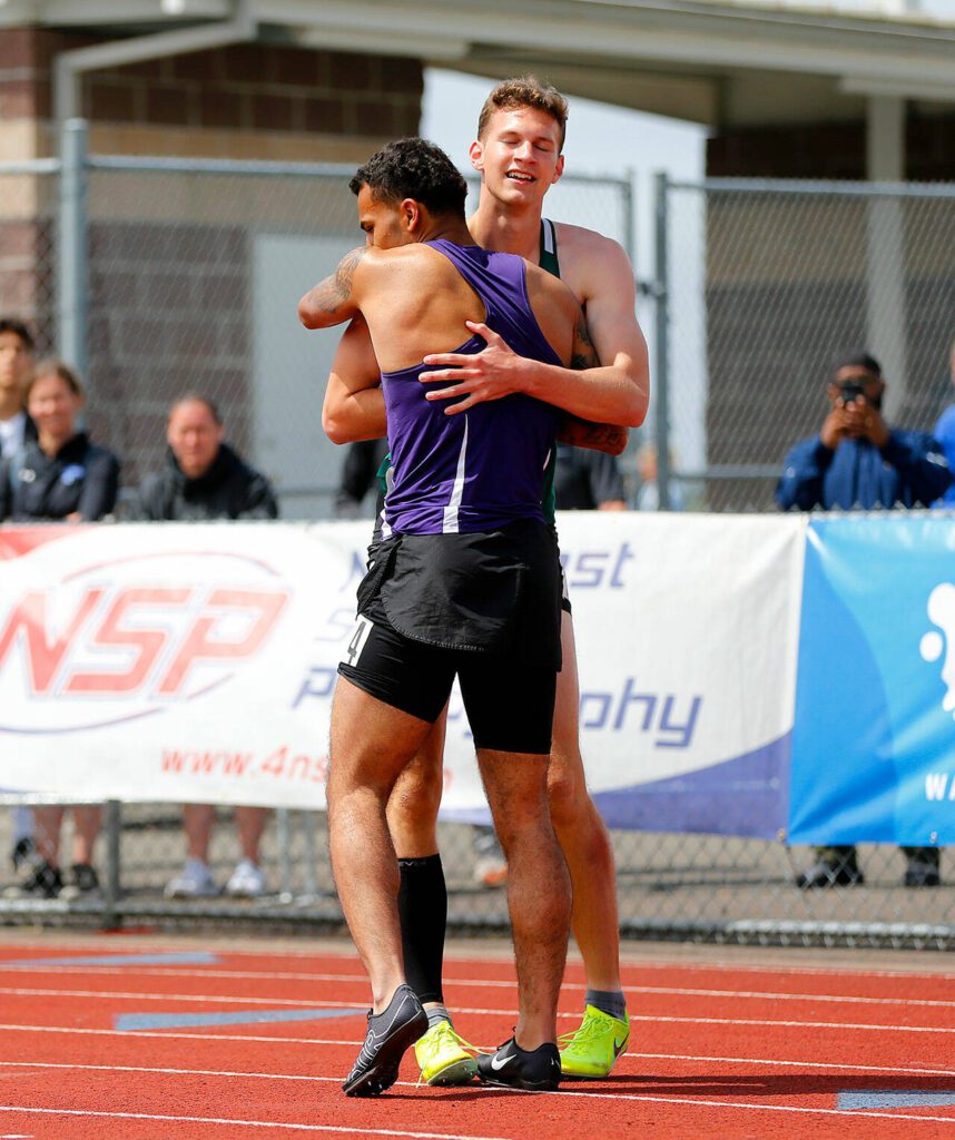 Kamiak’s Jaquan Means hugs Kentridge’s Alex Conner after finishing second to Conner in the 4A 300 meter hurdles during the WIAA State Track and Field Championships on Saturday, May 27, 2023, at Mount Tahoma High School in Tacoma, Washington. (Ryan Berry / The Herald)
