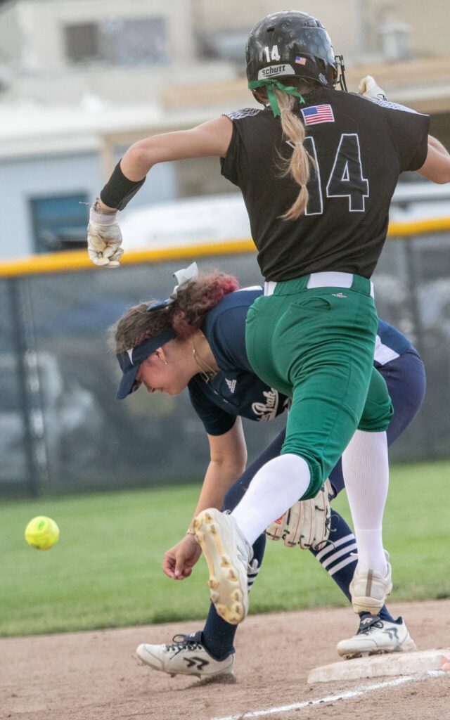 Jackson’s Macie Dean (14) hits a ball past first base and Katelyn McCallum (24) during the WIAA Class 4A state softball title game on Saturday, May 27, 2023, in Richland. (TJ Mullinax / For The Herald)
