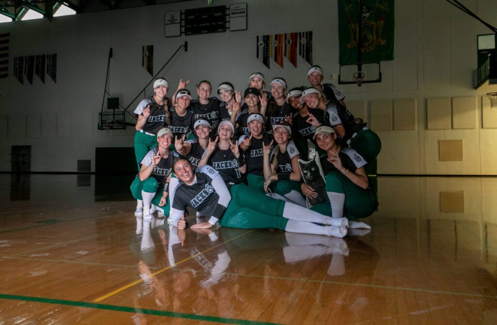 While waiting out a lightning and rain delay, Jackson players pose in an unlit gymnasium during the WIAA Class 4A state softball title game on Saturday, May 27, 2023, in Richland. (TJ Mullinax / For The Herald)
