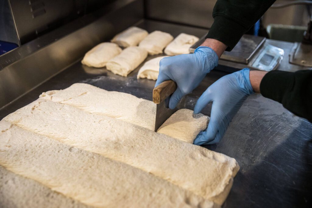 Dough is cut and weighed for the pizzas at Fire and the Feast on Tuesday, April 4, 2023 in Edmonds, Washington. (Olivia Vanni / The Herald)

