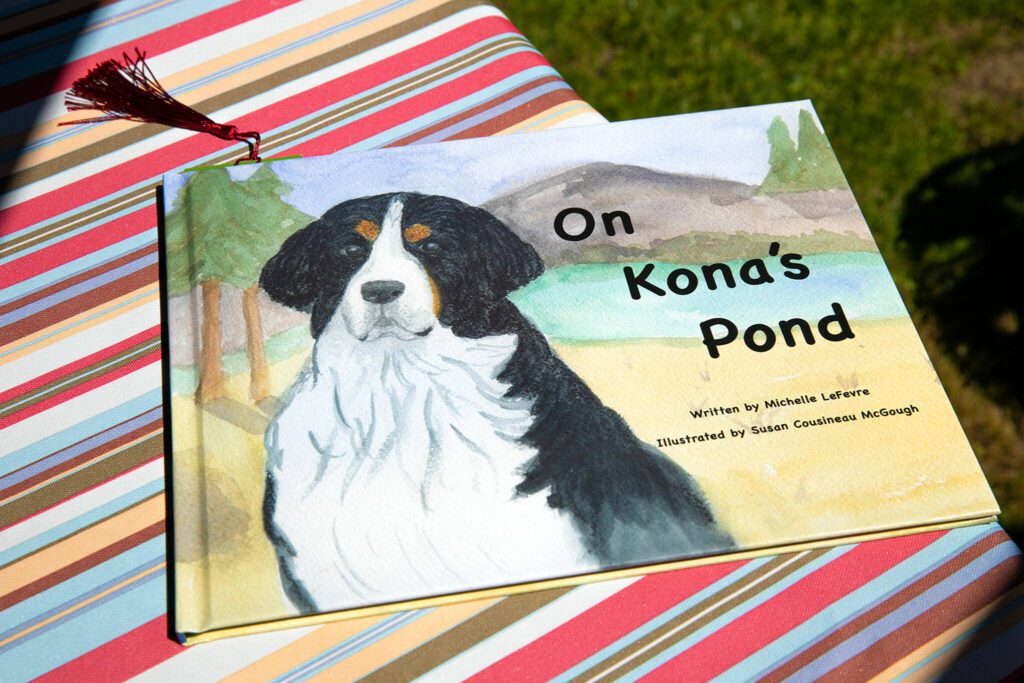 Michelle LeFevre’s book, “On Kona’s Pond” sits at picnic table at LeFevre’s home Wednesday, May 10, 2023, in Camano, Washington. (Ryan Berry / The Herald)
