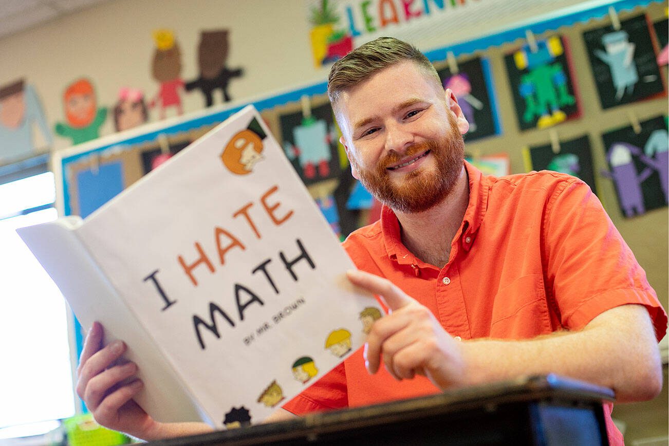 Challenger Elementary 3rd grade teacher Ian Brown holds his comic book “I Hate Math” in his classroom Thursday, June 1, 2023, in Everett, Washington. Brown wrote and illustrated the book while on a roughly half-year sabbatical from teaching duties. (Ryan Berry / The Herald)