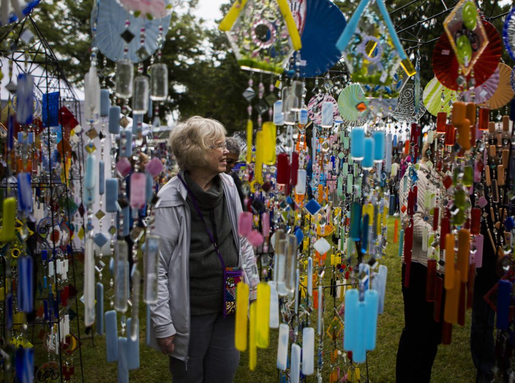 People browse through the different glass wind chimes during Sorticulture at Legion Memorial Park on Friday, June 7, 2019 in Everett, Wa. (Olivia Vanni / The Herald)
