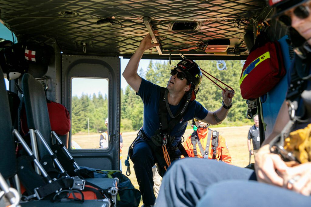 South County Fire’s Ryan Clancy climbs aboard the search and rescue Huey helicopter during an interagency disaster response training exercise at Arlington Municipal Airport on Tuesday, June 6, 2023, in Arlington, Washington. (Ryan Berry / The Herald)
