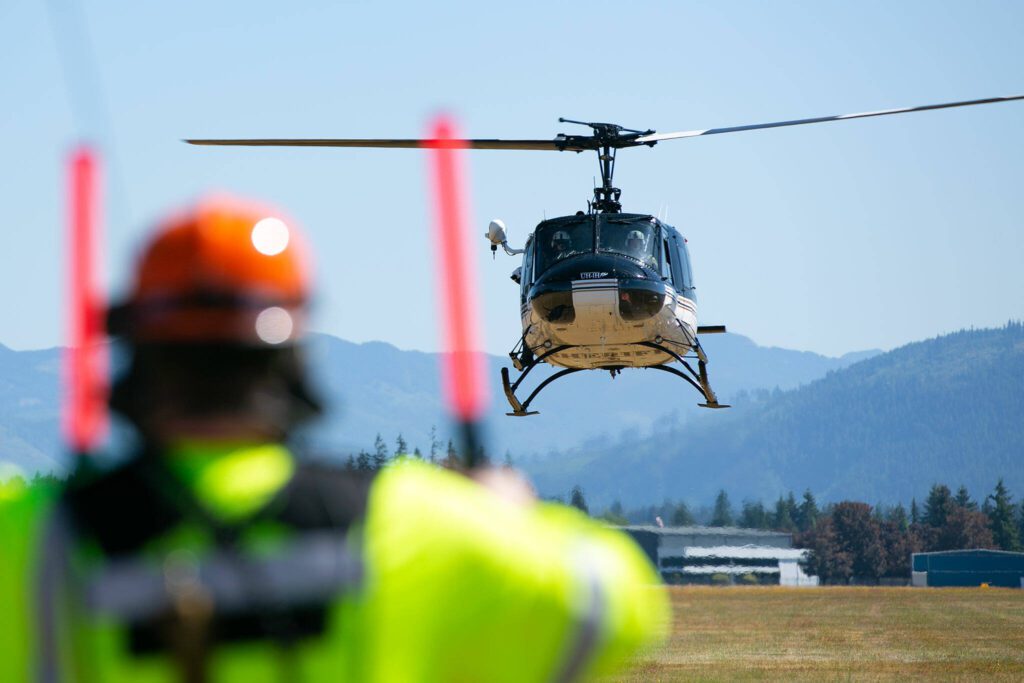 The flight crew from Snohomish County Volunteer Search and Rescue land in a field during an interagency disaster response training exercise at Arlington Municipal Airport on Tuesday, June 6, 2023, in Arlington, Washington. (Ryan Berry / The Herald)
