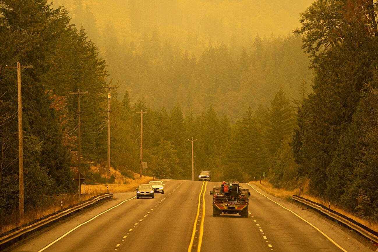 An emergency fire vehicle heads past a barricade and towards Index as numerous agencies attempt to contain the Bolt Creek Fire on Saturday, Sep. 10, 2022, on U.S. Highway 2 near Index, Washington. (Ryan Berry / The Herald)
