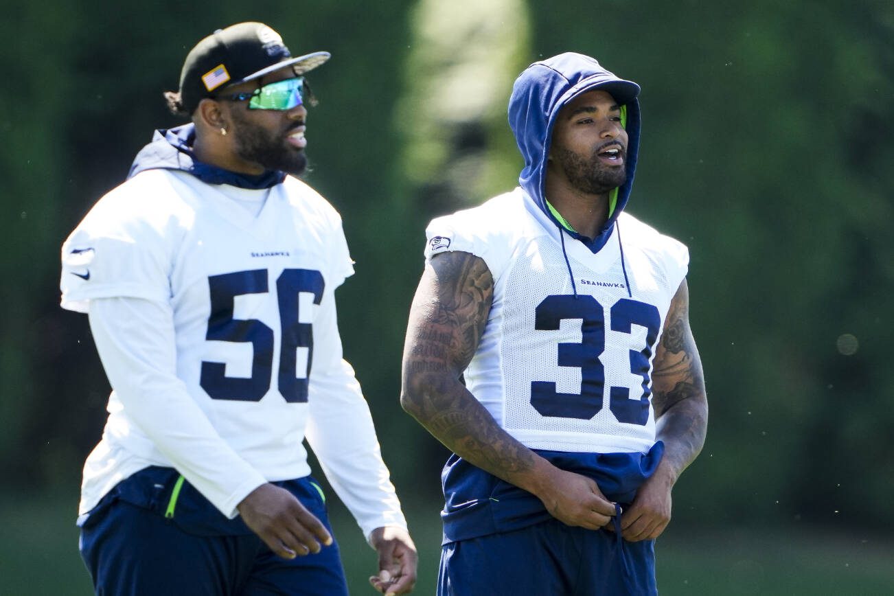 Seattle Seahawks linebacker Jordyn Brooks (56) and safety Jamal Adams (33) talk during NFL football practice, Tuesday, June 6, 2023, at the team's facilities in Renton, Wash. (AP Photo/Lindsey Wasson)