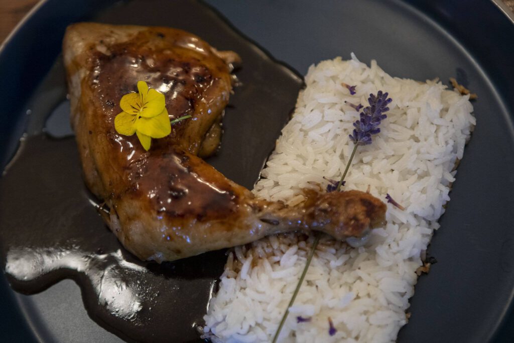 A coq au rhum dish with roasted chicken, lavender rice and pineapple-rum sauce at the Bush House Inn in Index, Washington on Monday, June 26, 2023. (Annie Barker / The Herald)
