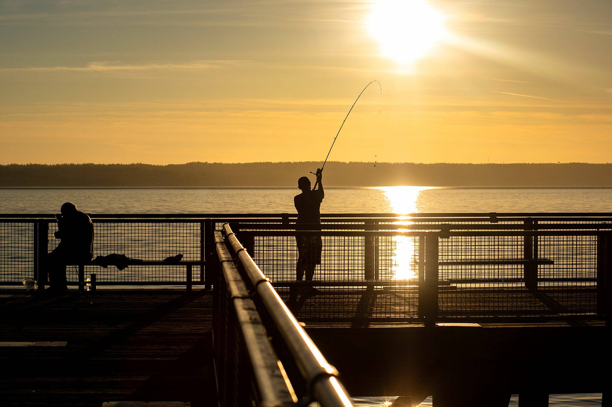 Ruvim Mesheryakov, celebrating his 12th birthday with family, casts his line out into the ocean from the pier at Kayak Point on Monday, June 12, 2023, in Stanwood, Washington. (Ryan Berry / The Herald)