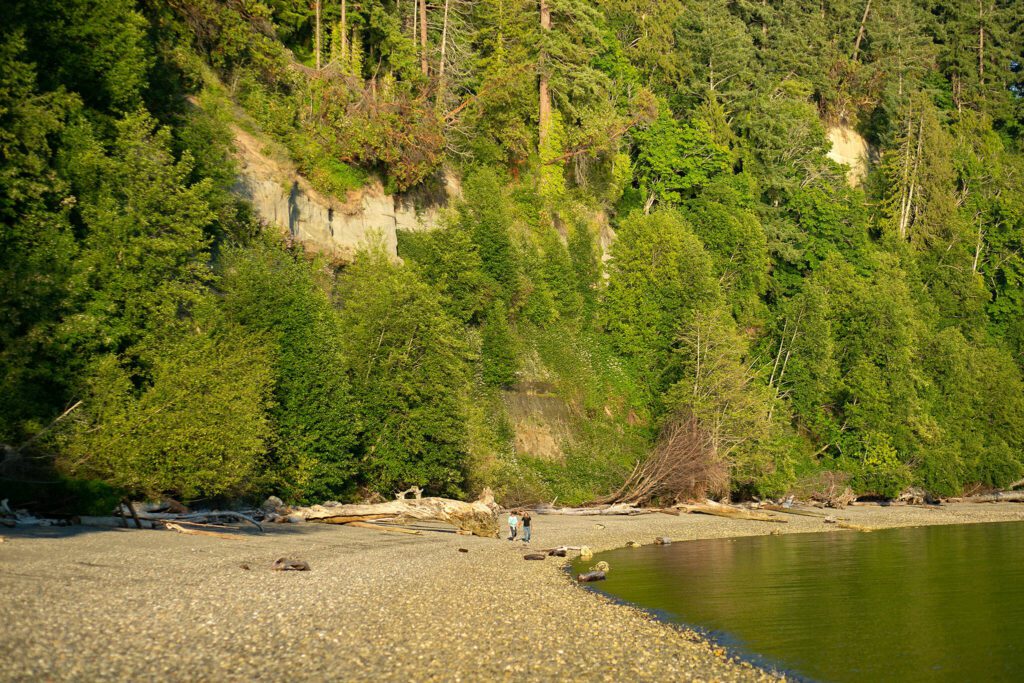 A couple walks back towards the park along the south shoreline of Kayak Point on Monday, June 12, 2023, in Stanwood, Washington. (Ryan Berry / The Herald)
