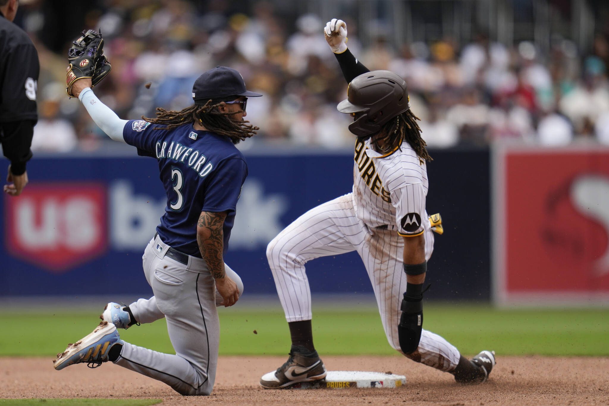 The Padres’ Fernando Tatis Jr. (right) gets up after stealing second base as Mariners shortstop J.P. Crawford looks on during the fourth inning of a game Wednesday in San Diego. (AP Photo/Gregory Bull)