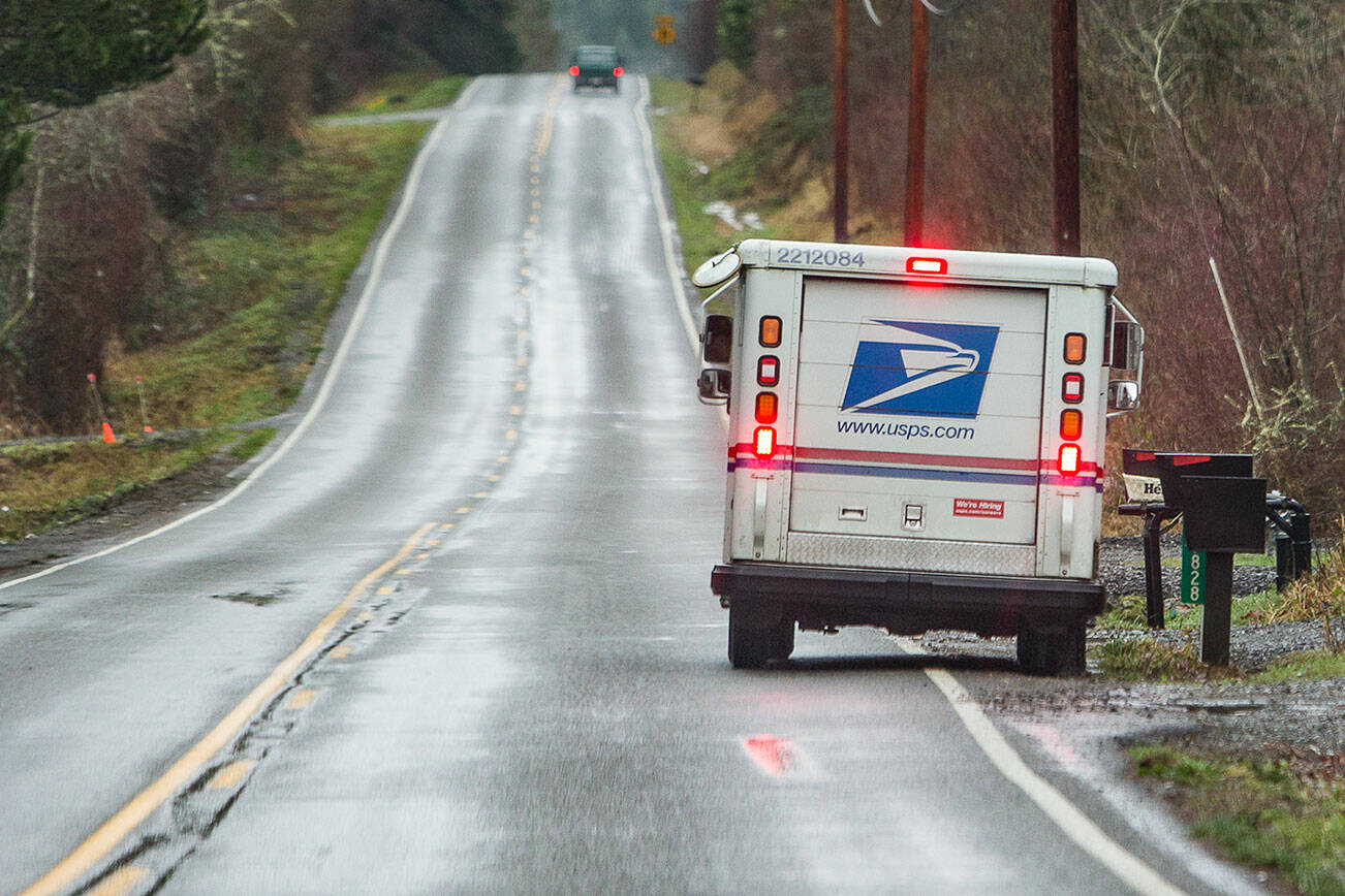 A mail carrier delivers mail along Dubuque Road in Snohomish on Wednesday, Jan. 12, 2022. (Olivia Vanni / The Herald)