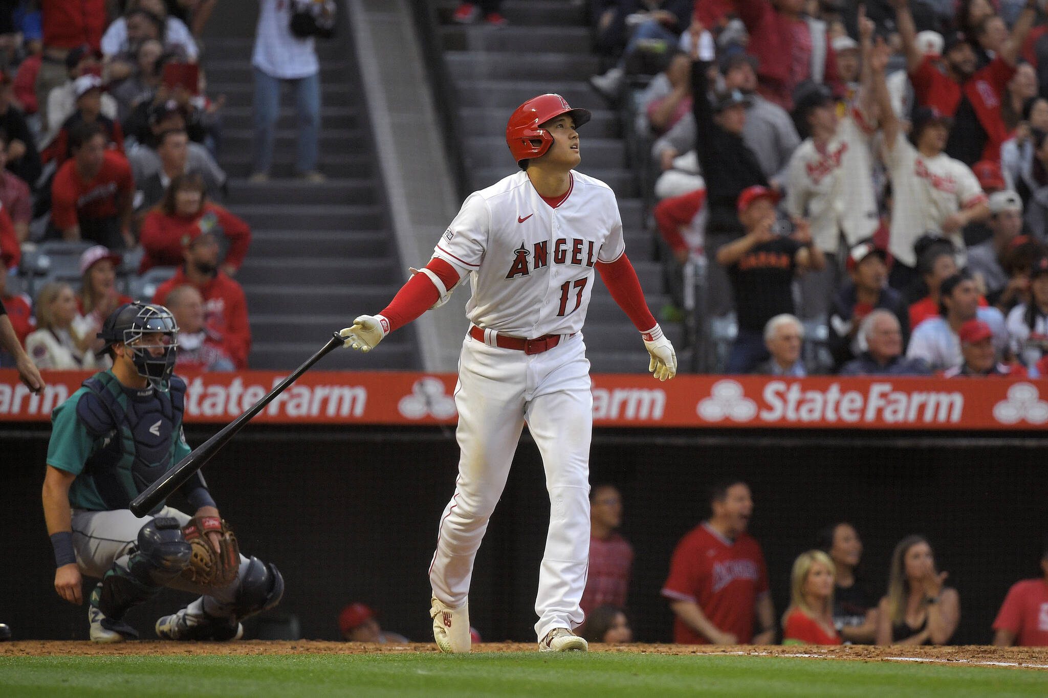 The Angels’ Shohei Ohtani drops his bat after hitting a two-run home run as Mariners catcher Cal Raleigh watches during the third inning of a game Friday in Anaheim, Calif. (AP Photo/Mark J. Terrill)