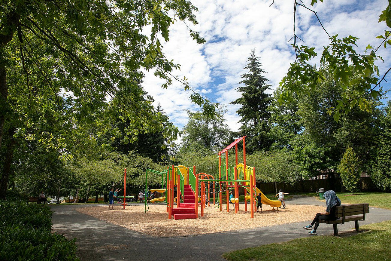 Children play on the playground at Spruce Park, near where two teenagers were shot and killed in a drive-by shooting the night before, on Friday, July 15, 2022, in Lynnwood, Washington. (Ryan Berry / The Herald)