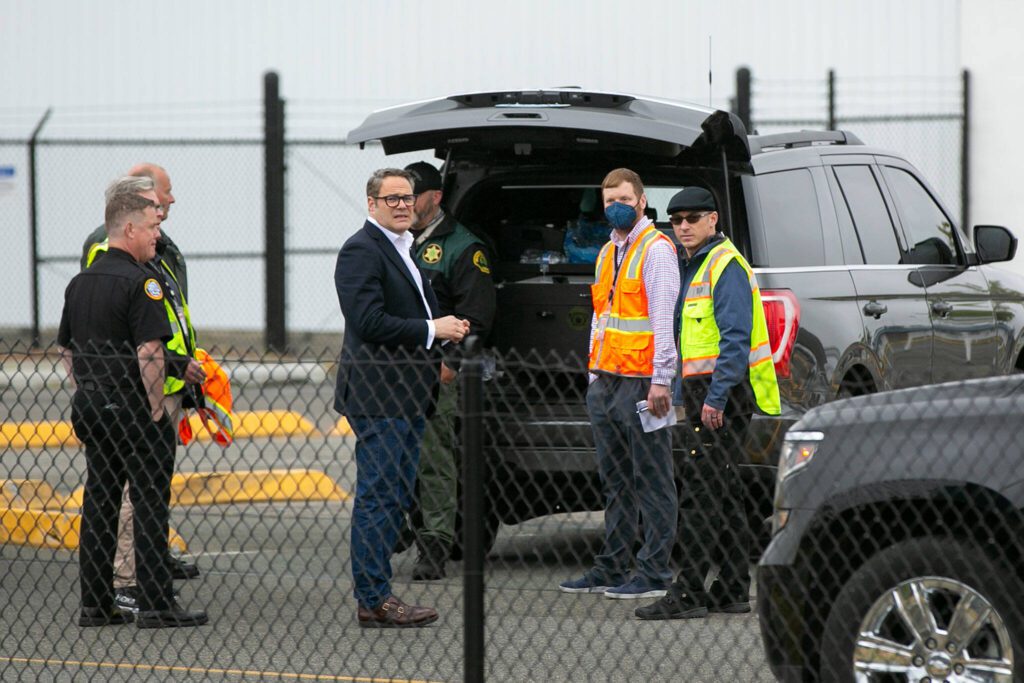 Brett Smith, CEO of Propeller Airports, meets with law enforcement and others outside Paine Field’s terminal after the discovery of a suspicious package at the airport on Tuesday, June 13, 2023, in Everett, Washington. (Ryan Berry / The Herald)
