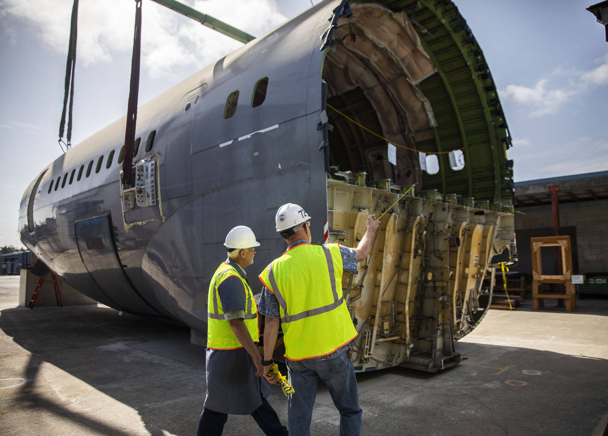 Brian Wilson, left, and Ron Fronheiser, right, survey the fuselage after it is placed at Edmonds College’s Advance Manufacturing Skill Center at Paine Field on Thursday, June 15, 2023 in Everett, Washington. (Olivia Vanni / The Herald)