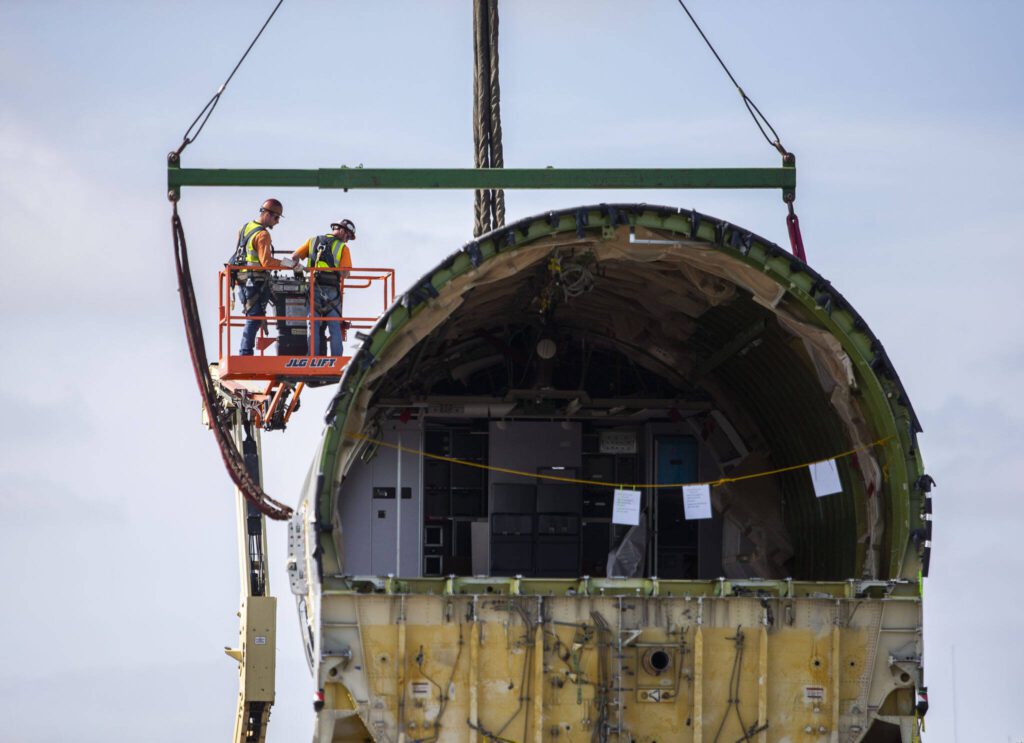 Omega Morgan employees secure steps to the the fuselage before the crane can move it on Thursday, June 15, 2023 in Everett, Washington. (Olivia Vanni / The Herald)

