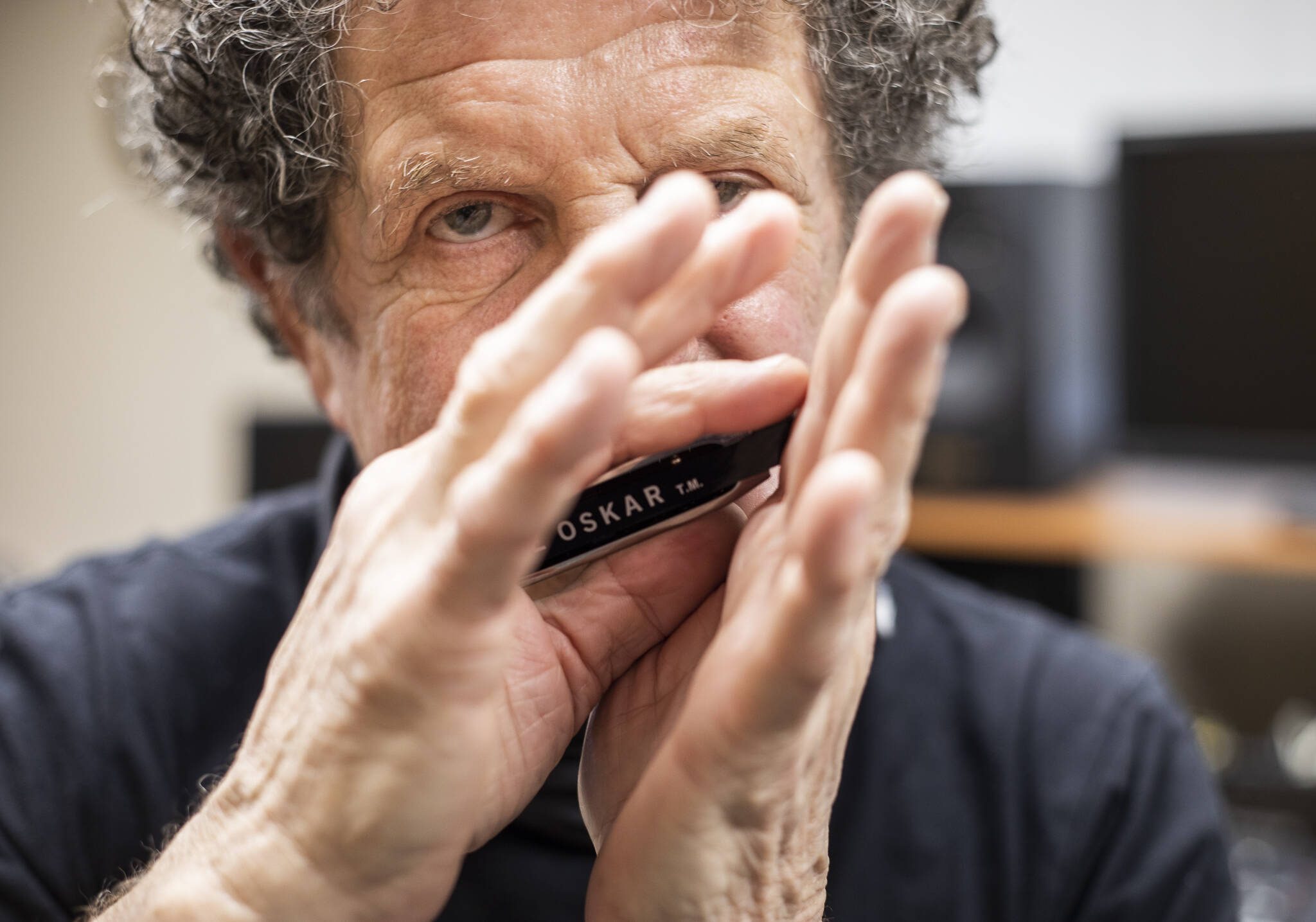 Lee Oskar plays one of his custom harmonicas in his recording studio in his Everett home in March 2022. (Olivia Vanni / The Herald)