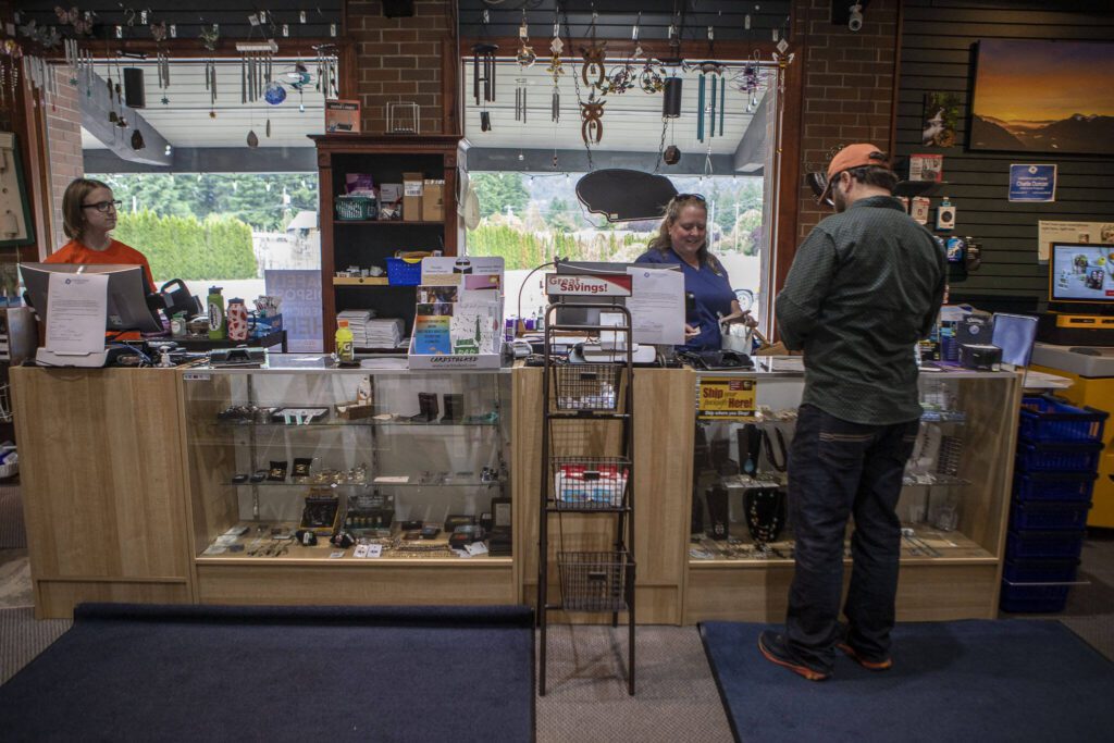 Sheila Sisney, 44, right, rings up a customer at the Darrington Pharmacy in Darrington, Washington on Friday, June 16, 2023. The pharmacy is closing on July 21, 2023. (Annie Barker / The Herald)
