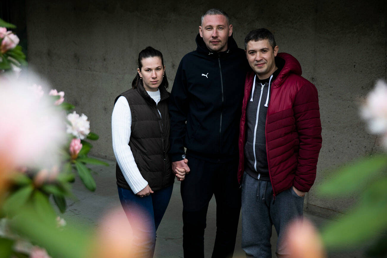 Husband and wife Nataliia Ktitorova, Vitalii Ktitorov and brother-in-law Yosip Lakatosh, right, at the Refugee & Immigrant Services Northwest office on Thursday, March 24, 2022 in Everett, Washington. (Olivia Vanni / The Herald)
