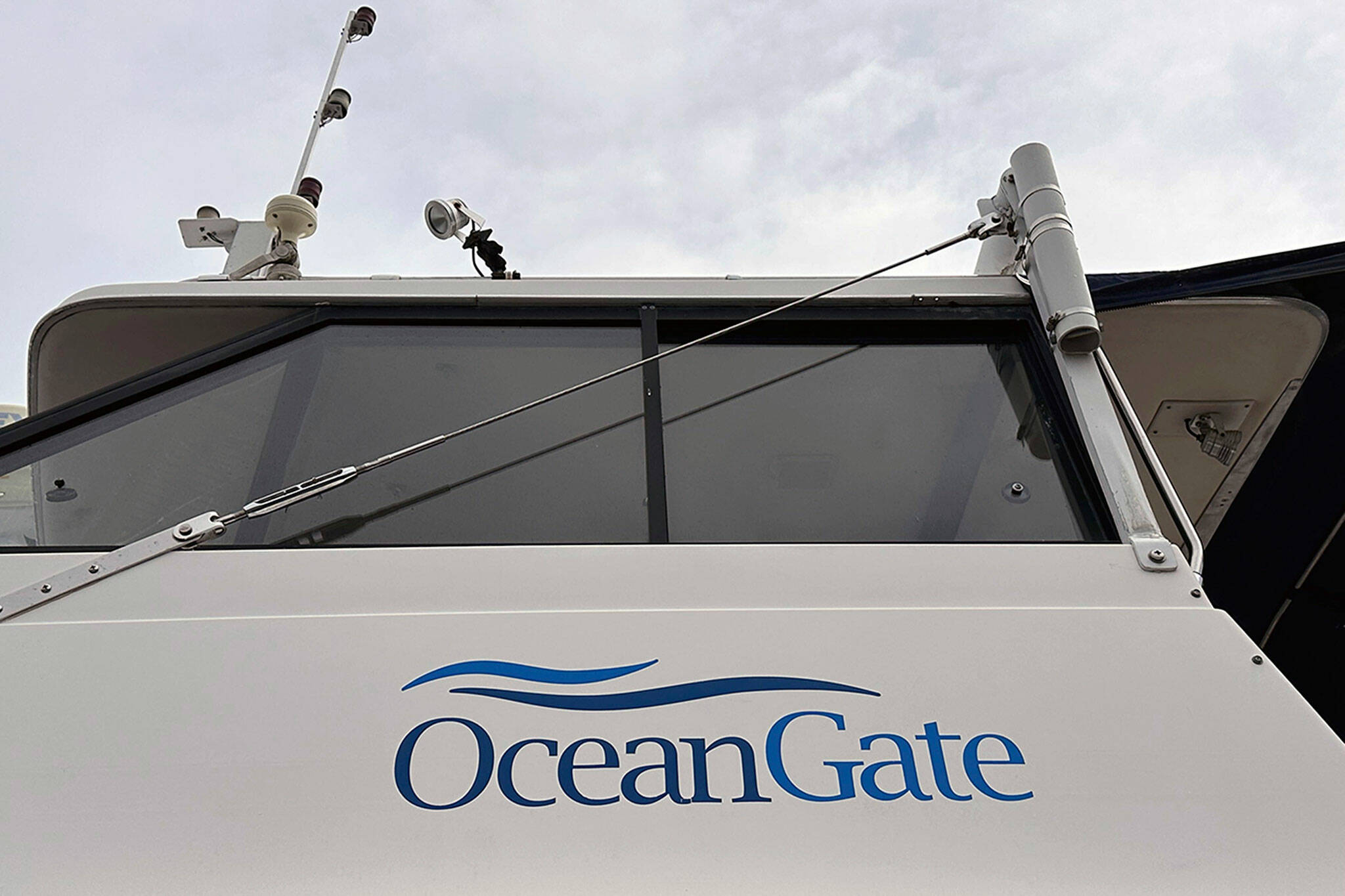 The logo for OceanGate Expeditions is seen on a boat parked near the offices of the company at a marine industrial warehouse office door in Everett, Washington, Tuesday, June 20, 2023. Rescuers raced against time to find the missing submersible carrying five people, who were reported overdue Sunday night. (AP Photo/Ed Komenda)