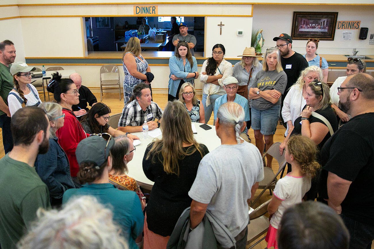 Dozens of neighbors pack around Ben Breeden, Homeless Response Coordinator for the city of Everett, to express concern about a proposed homeless day shelter during a public meeting at Our Lady of Hope’s parish hall Thursday, June 29, 2023, in Everett, Washington. (Ryan Berry / The Herald)