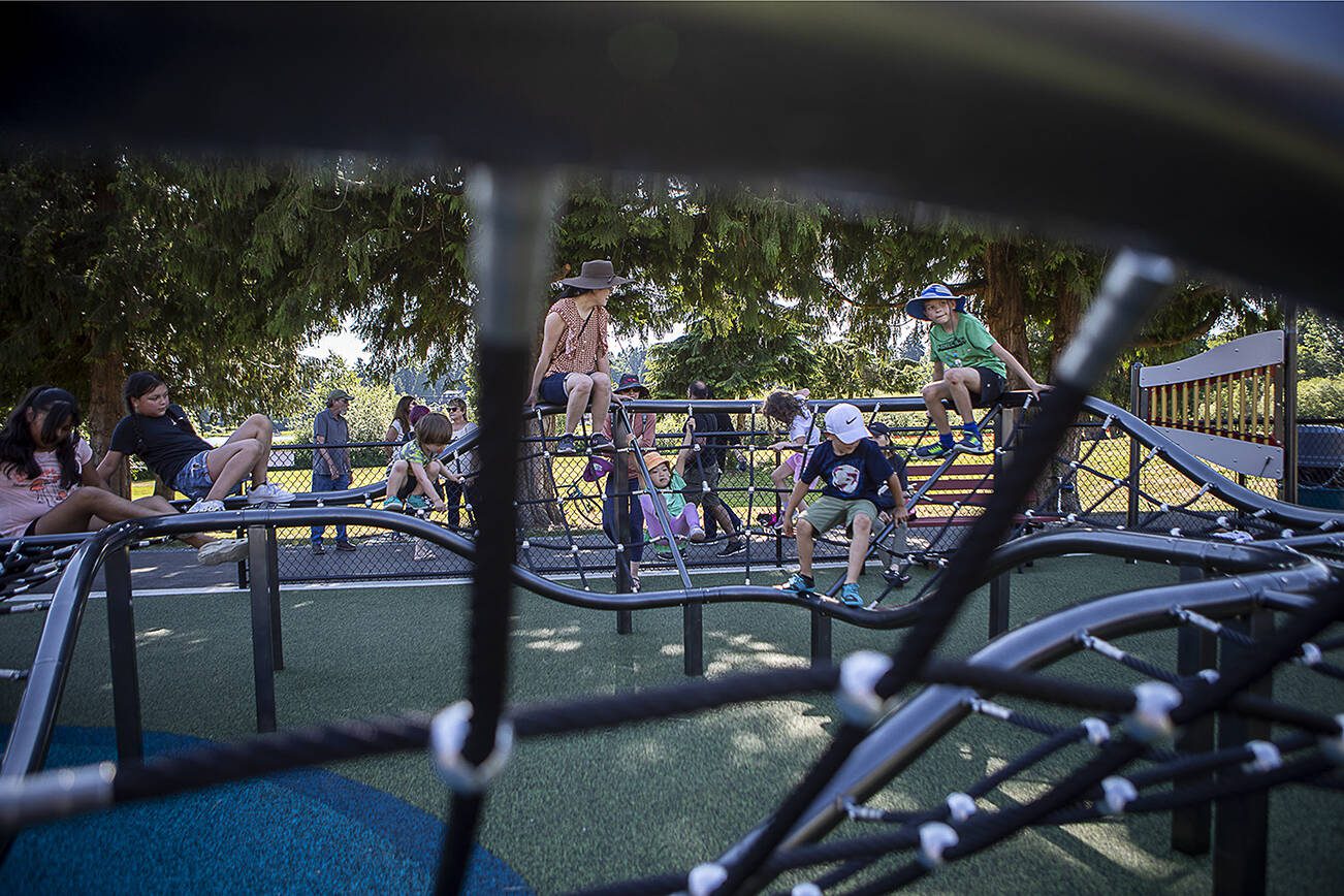 Children and adults climb on a jungle gym at the Hazel Miller Universally Accessible Playground at Ballinger Park in Mountlake Terrace, Washington on Wednesday, June 28, 2023. (Annie Barker / The Herald)