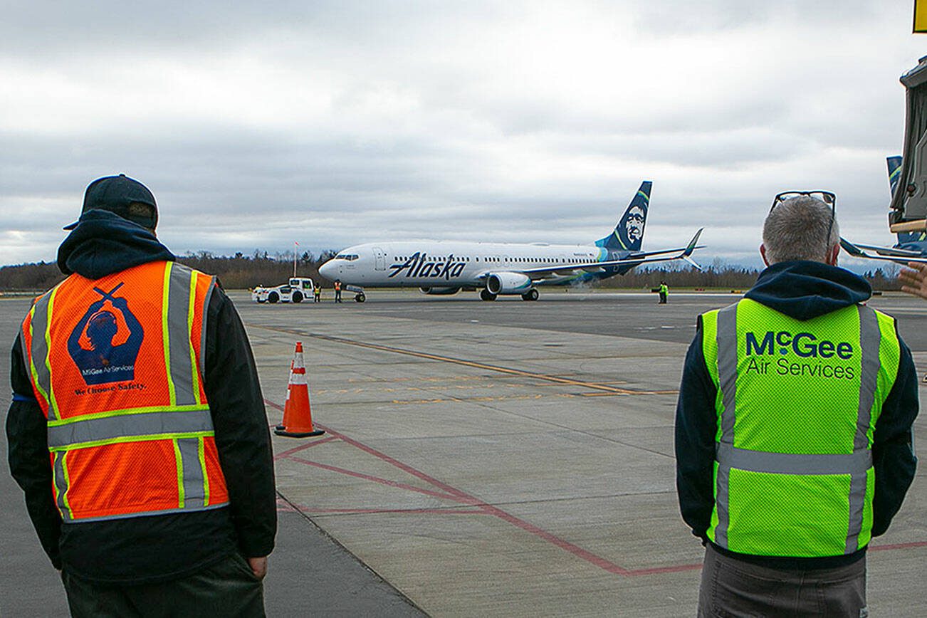 Employees stand and watch the first Boeing 737 at Paine Field prepare to take off Thursday, Feb. 17, 2022, in Everett, Washington. (Ryan Berry / The Herald)