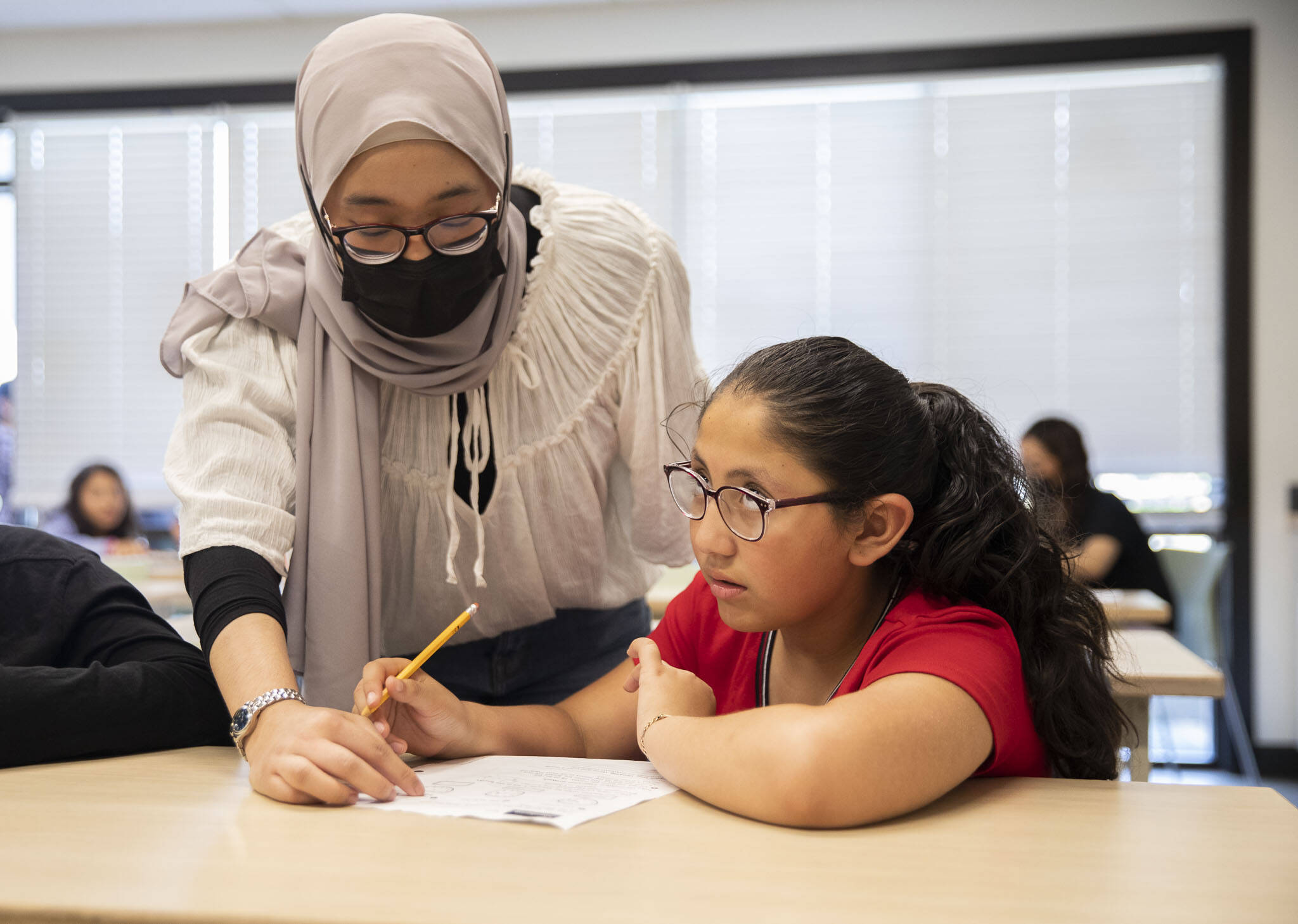 Ashley Cabrera, 9, thinks through a math problem with the help of tutor Aleesya Jasmi. (Olivia Vanni / The Herald)