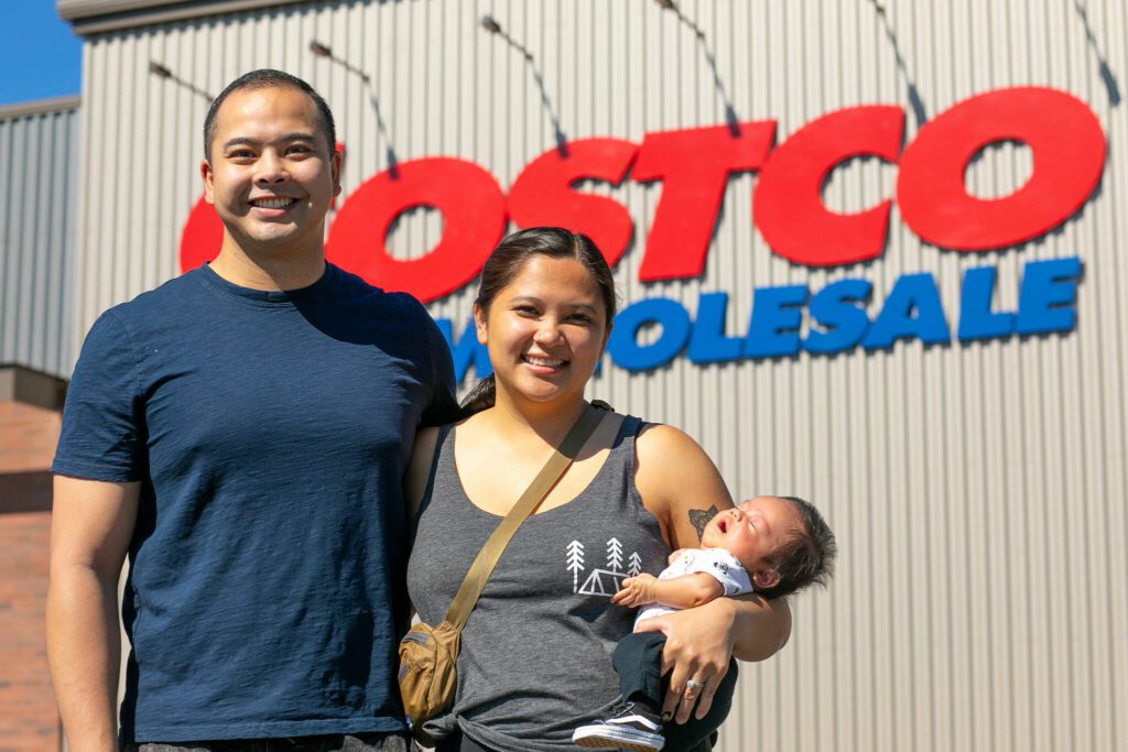 Angelo and Jona Sarmiento, along with baby Carlisle, stand in front of the Lake Stevens Costco where Jona went into labor with the couple’s first child on May 25. (Ryan Berry / The Herald)

