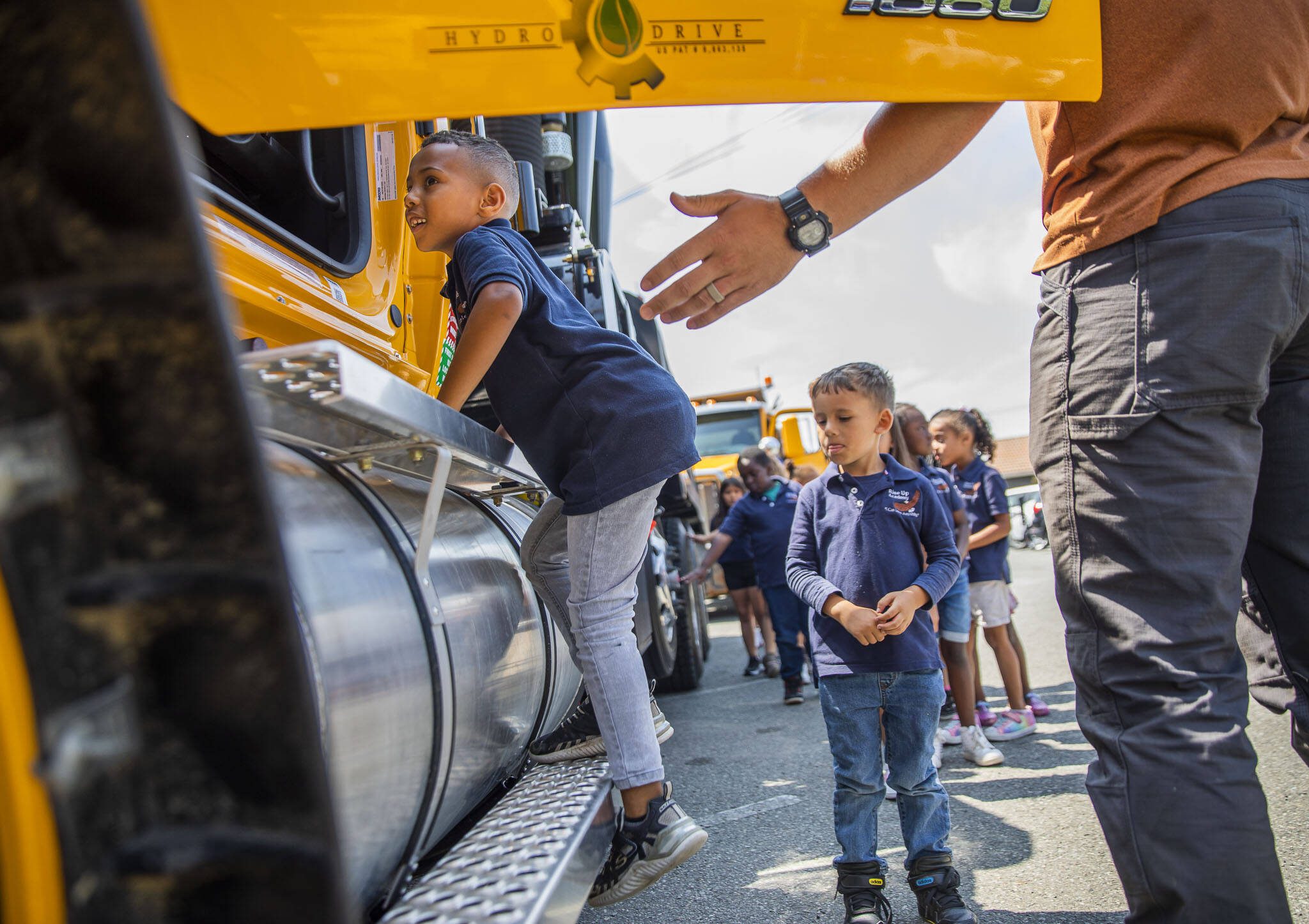 Michael Fekede, 5, climbs up into a truck during an event announcing funding for affordable child care slots held at Rise Up Academy on Thursday, July 6, 2023 in Everett, Washington. Rise Up Academy is one of a handful of child care facilities awarded funds to help increase child care slots. (Olivia Vanni / The Herald)