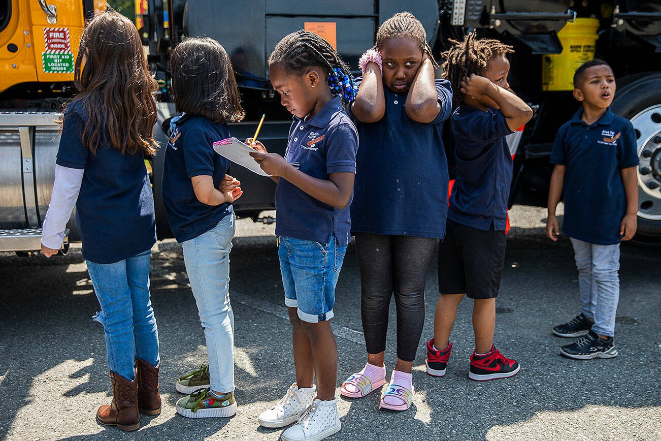 Binta Sanneh, 5, left, and Binta Sanneh, 6, right, line up along with other Rise Up Academy students to get a chance to climb into a truck on Thursday, July 6, 2023 in Everett, Washington. (Olivia Vanni / The Herald)