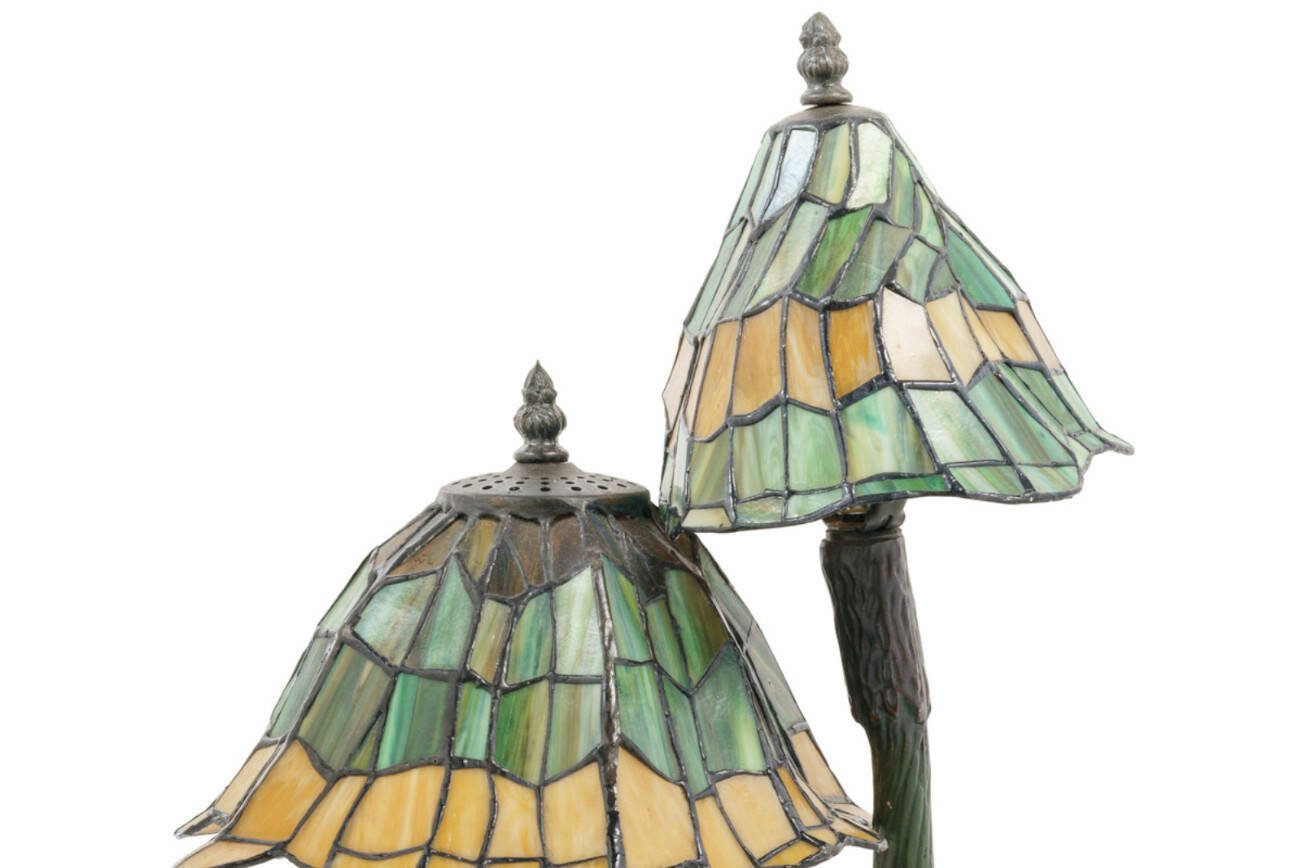 This lamp's maker has not been identified, but it resembles the famous Tiffany lamps of the early 20th century. Its mushroom motif and narrow, asymmetrical curves recall the stylized nature shapes of art nouveau.