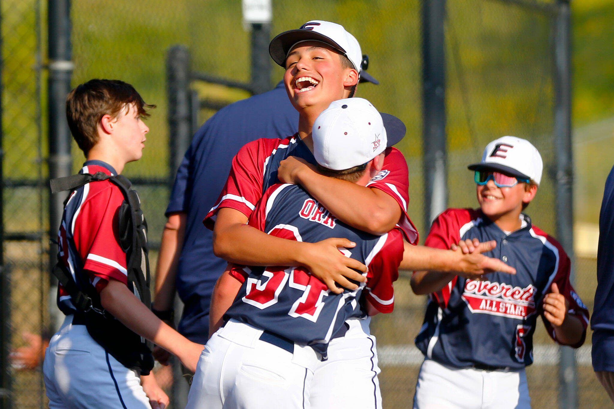 Everett All Star Mason Carmona hugs pitcher Jimi Orr (34) after closing out the game for a win over Lake Stevens during a 12u Little League matchup on Wednesday, July 5, 2023, at the Phil Johnson Ballfields in Everett, Washington. (Ryan Berry / The Herald)