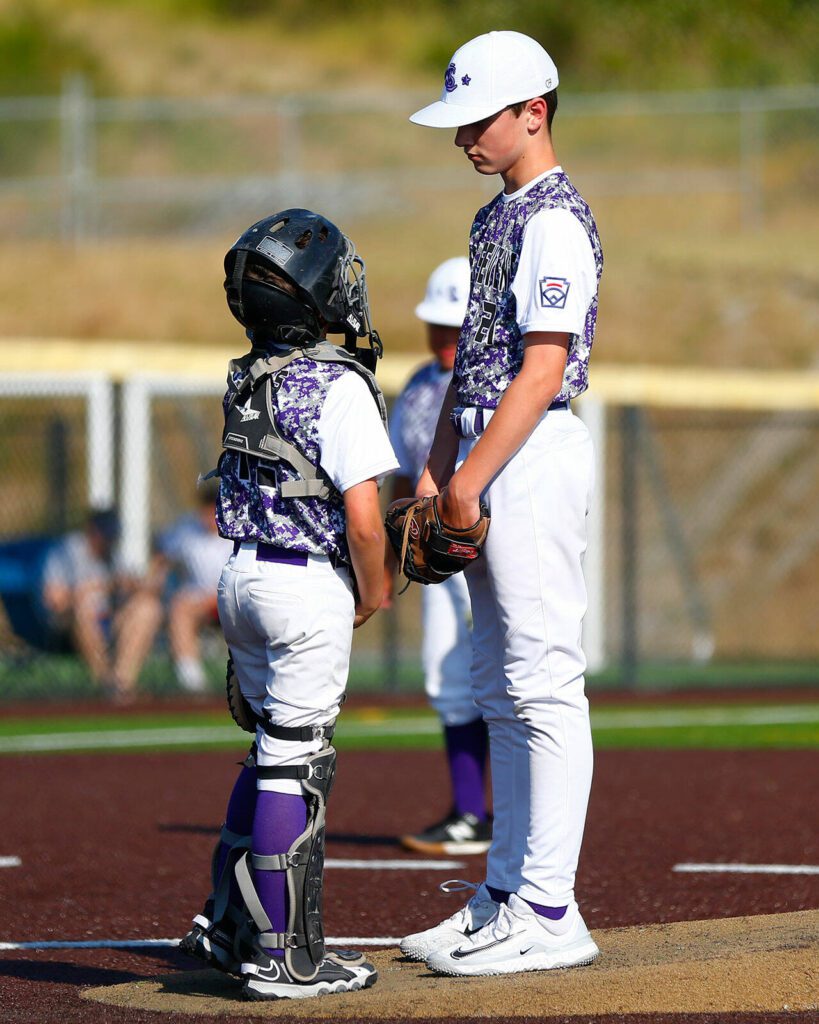Lake Stevens All Star catcher Weston Cross chats with pitcher Joel Dellino before the start of an inning against Everett during a 12u Little League matchup on Wednesday, July 5, 2023, at the Phil Johnson Ballfields in Everett, Washington. (Ryan Berry / The Herald)
