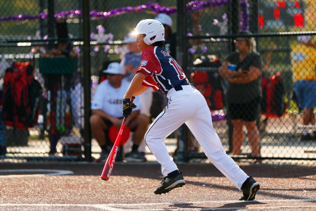 Everett All Star Ray Flores runs to first after putting the ball in play against Lake Stevens during a 12u Little League matchup on Wednesday, July 5, 2023, at the Phil Johnson Ballfields in Everett, Washington. (Ryan Berry / The Herald)
