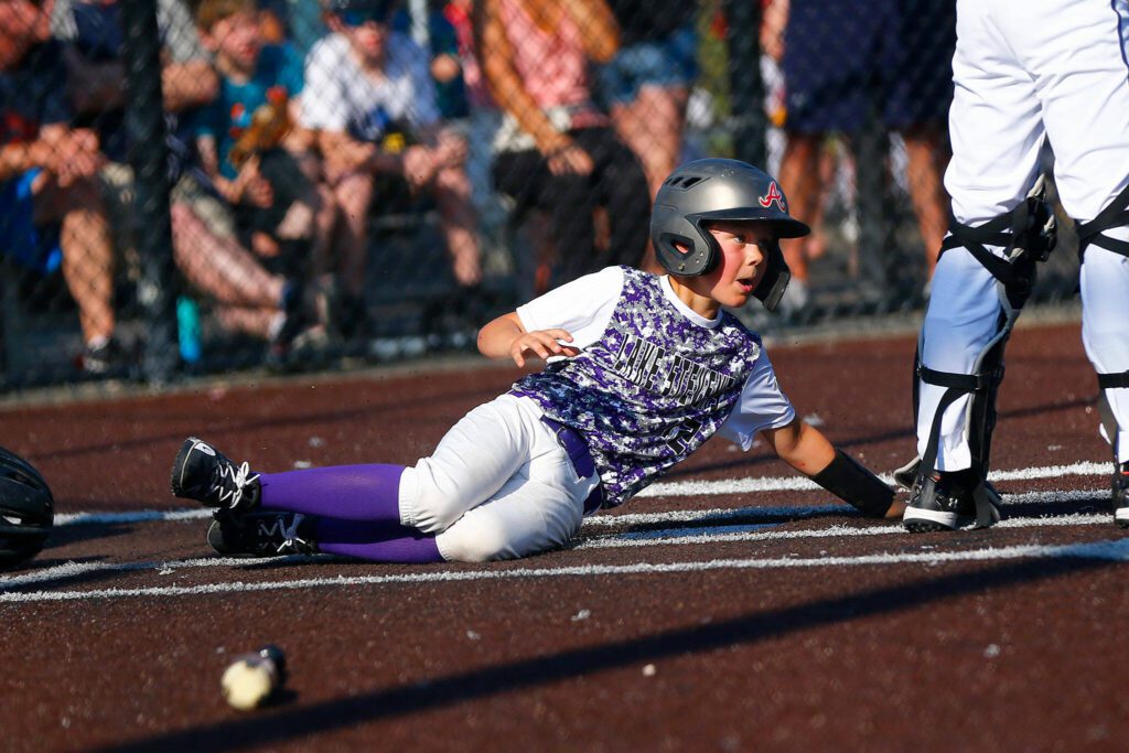 Lake Stevens All Star Weston Cross slides in at home against Everett during a 12u Little League matchup on Wednesday, July 5, 2023, at the Phil Johnson Ballfields in Everett, Washington. (Ryan Berry / The Herald)

