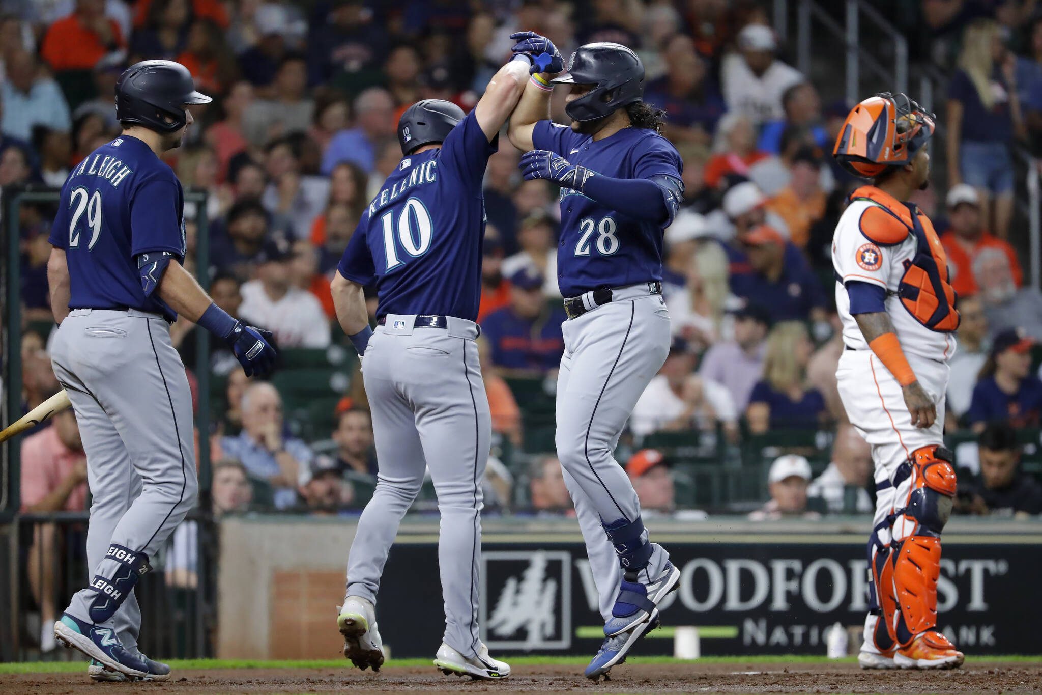 The Mariners’ Eugenio Suarez (28) celebrates with Jarred Kelenic after hitting a home run during the second inning of a game Thursday in Houston. (AP Photo/Michael Wyke)