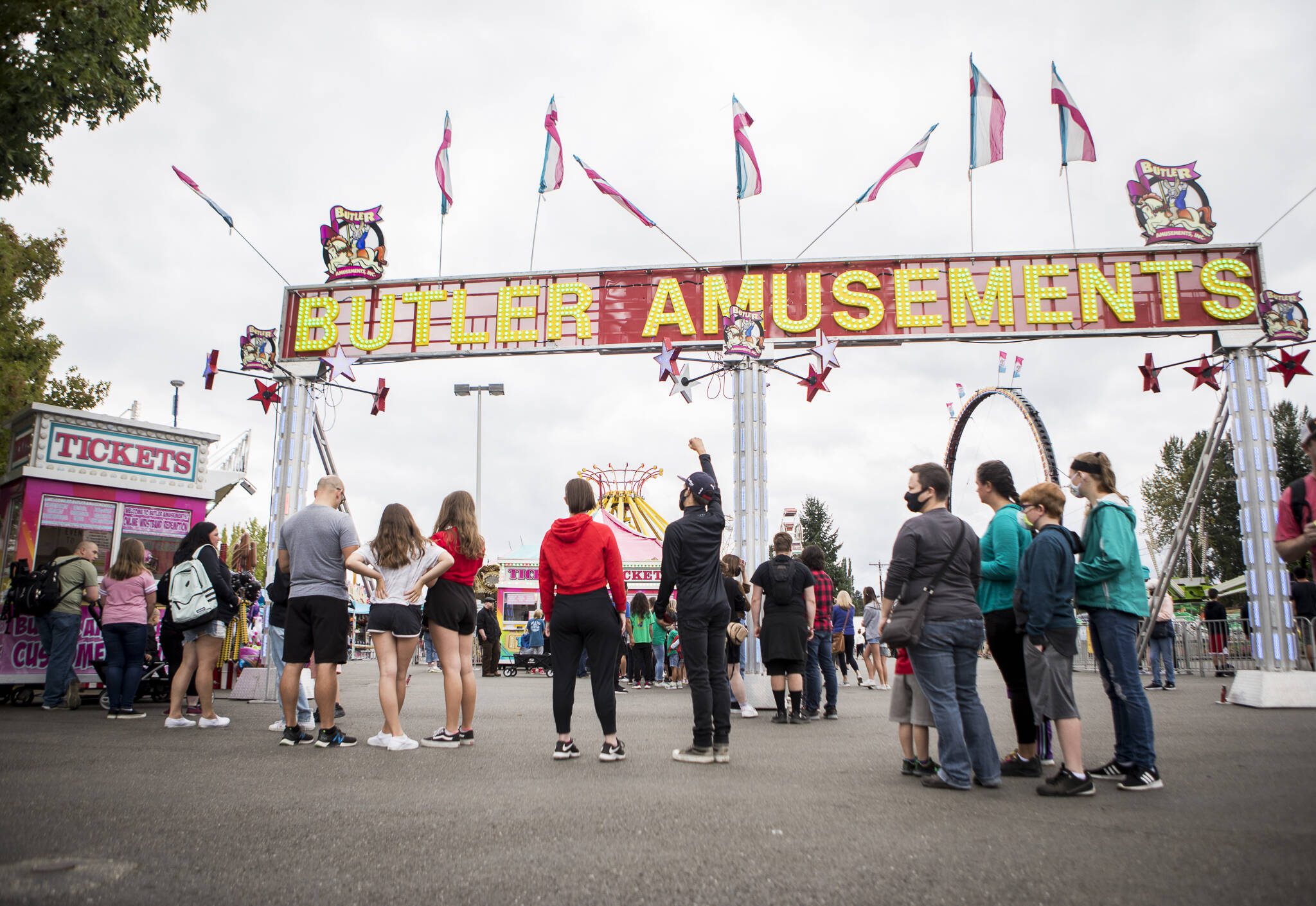 People wait in line for amusement park tickets during opening day of the Evergreen State Fair on Thursday, Aug. 26, 2021 in Monroe, Wash. (Olivia Vanni / The Herald)