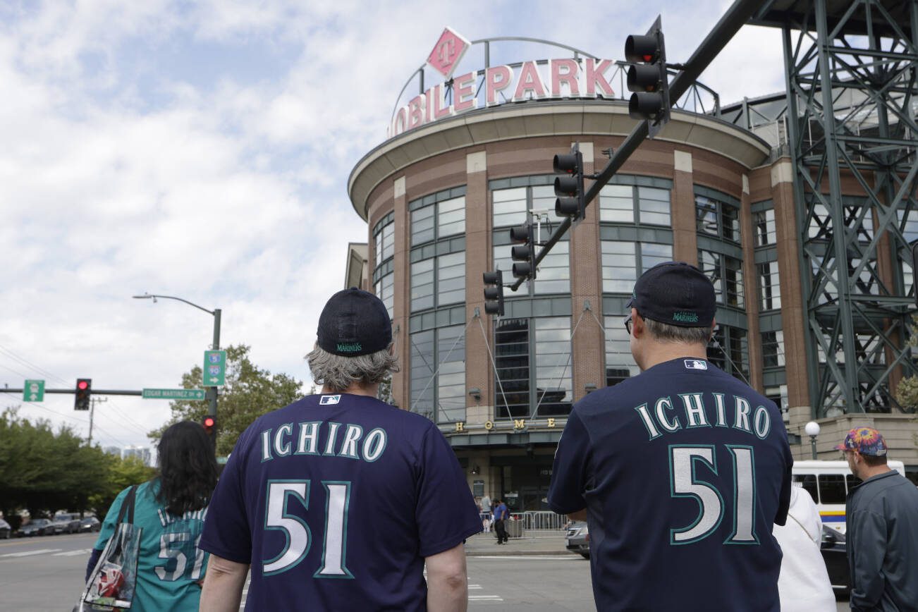 Fans wearing jersey's with the name of former Seattle Mariners player Ichiro Suzuki walk to T-Mobile Park before a baseball game between the Mariners and the Cleveland Guardians, Saturday, Aug. 27, 2022, in Seattle. Suzuki is to be inducted into the Mariners Hall of Fame in a pre-game ceremony. Ichiro, who prefers to use only his first name, joins 9 other Mariners already in the Mariners HOF. He is a 10-time All-Star and American League Rookie of the Year in 2001.. (AP Photo/John Froschauer)