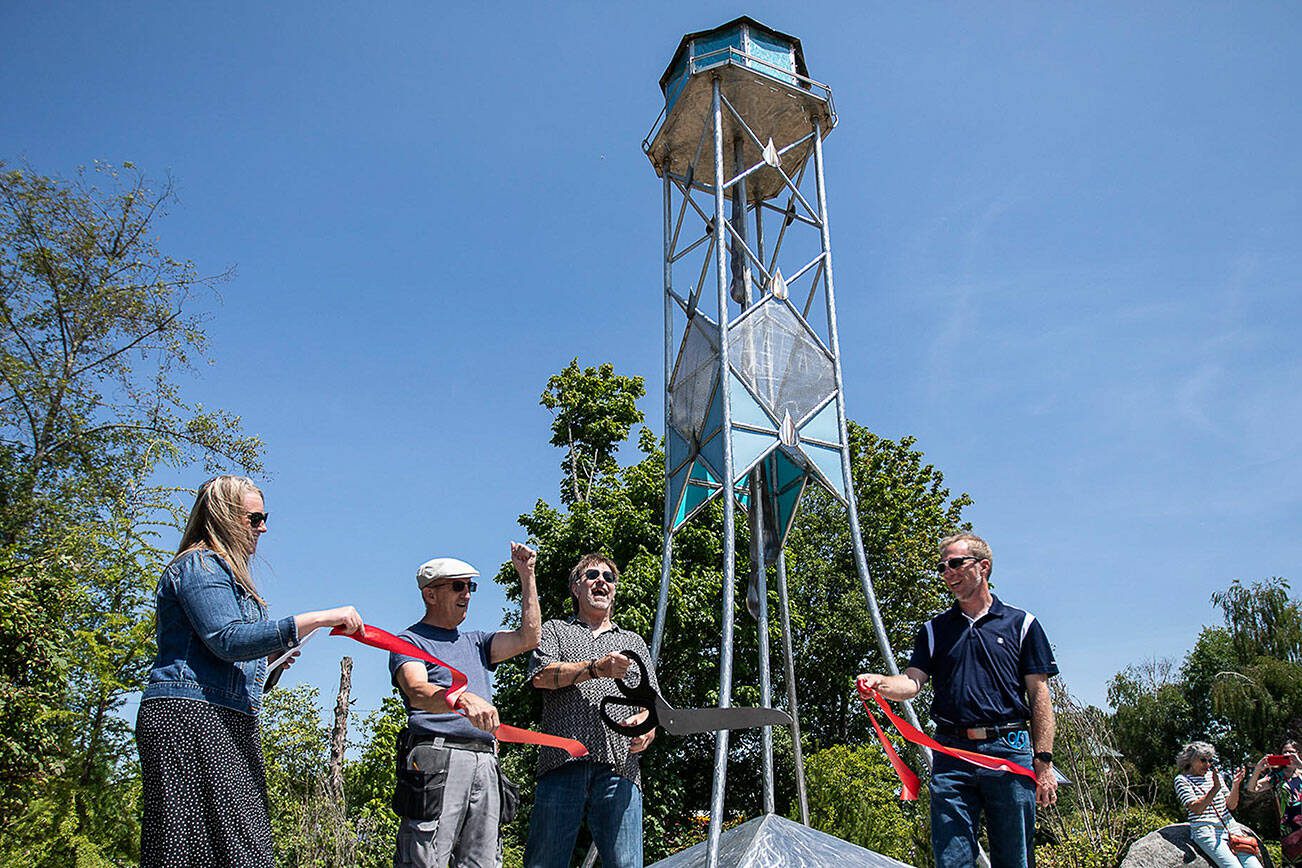 Joe Powers, the artist that created the Lake Stevens Water Tower art piece, cheers after cutting the ribbon during the ribbon-cutting ceremony on Thursday, July 20, 2023 in Lake Stevens, Washington. (Olivia Vanni / The Herald)
