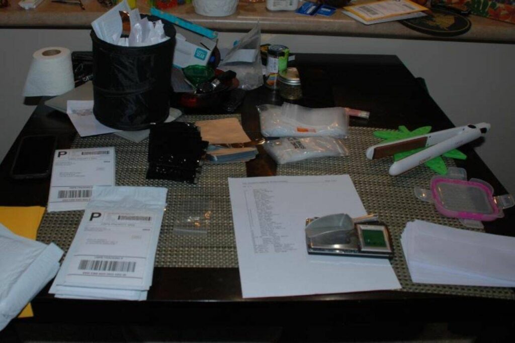 Mailers, labels, and a list of names and corresponding amounts of controlled substances to be shipped found on Linus Lee’s the living room table. (U.S. Attorney’s Office)
