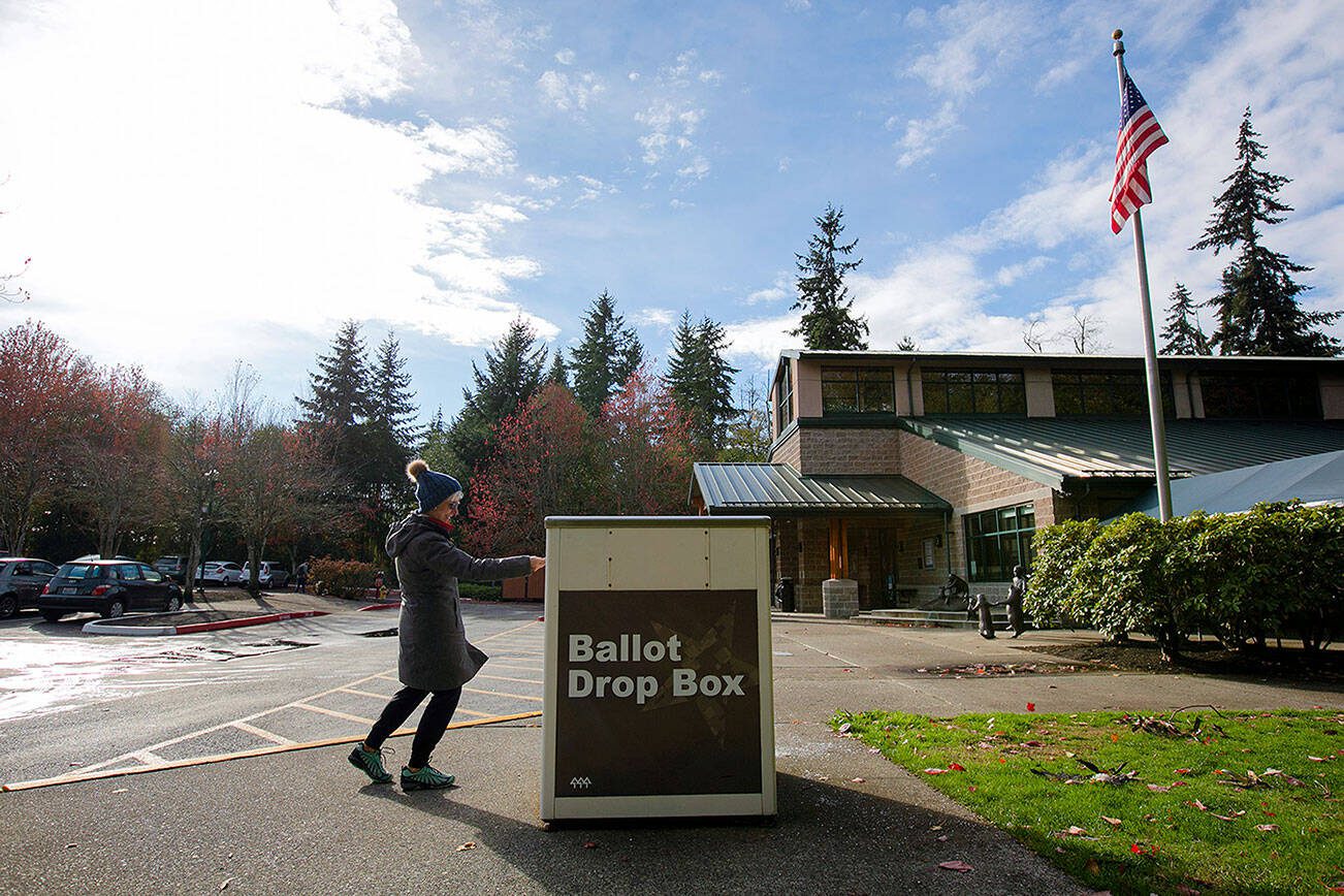 A voter drops off her ballot at the drop box in front of the Mukilteo Library on Tuesday, Nov. 8, 2022, in Mukilteo, Washington. (Ryan Berry / The Herald)